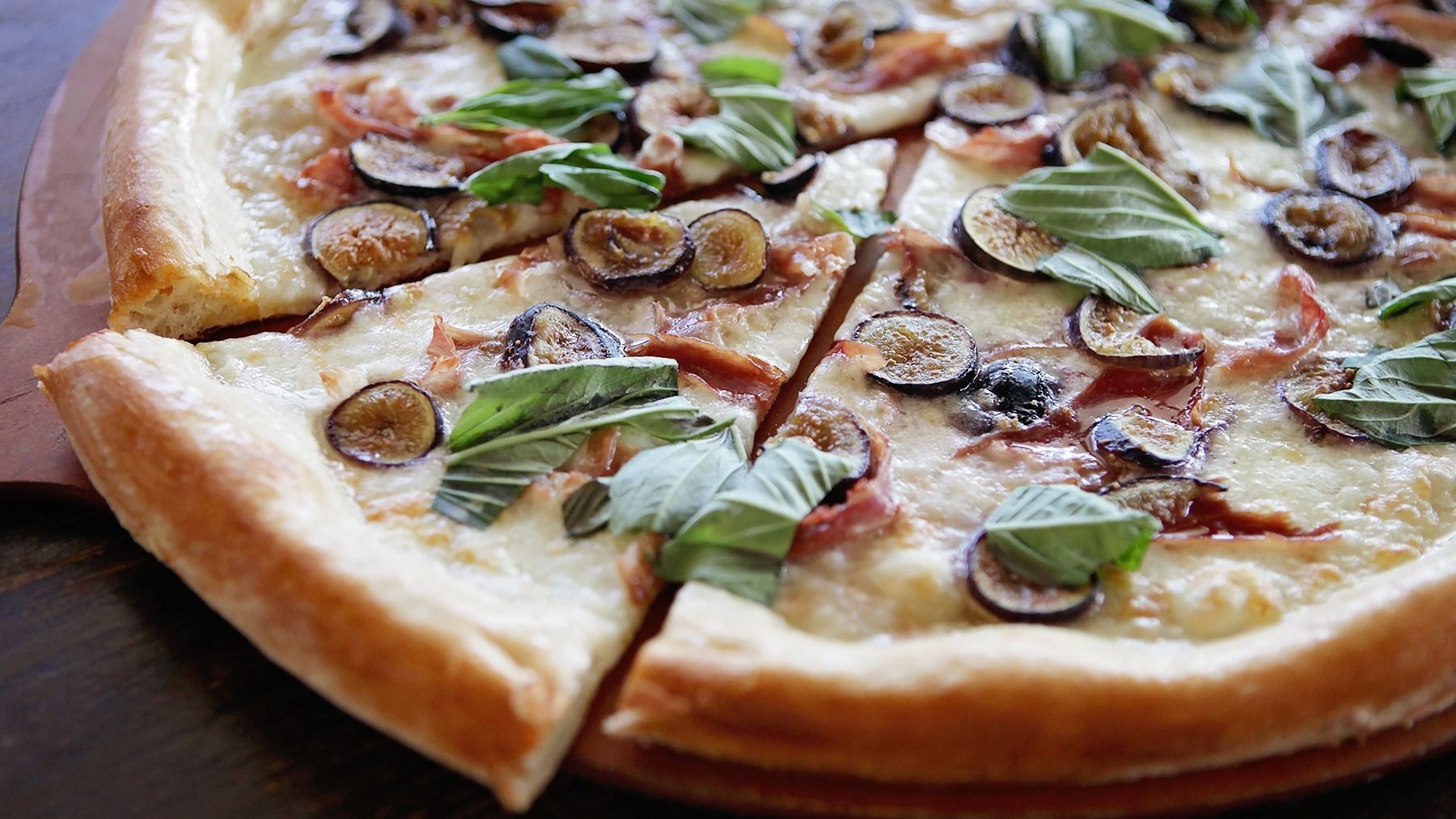 In Italy, luscious, ripe figs and delicate, salty prosciutto are a prized flavor combination—one of those perfect salty-sweet mixes. We use farm-fresh figs and premium prosciutto, layering generous portions of each over mozzarella on an olive oil base. Out of the oven, we finish the pizza with minced basil.