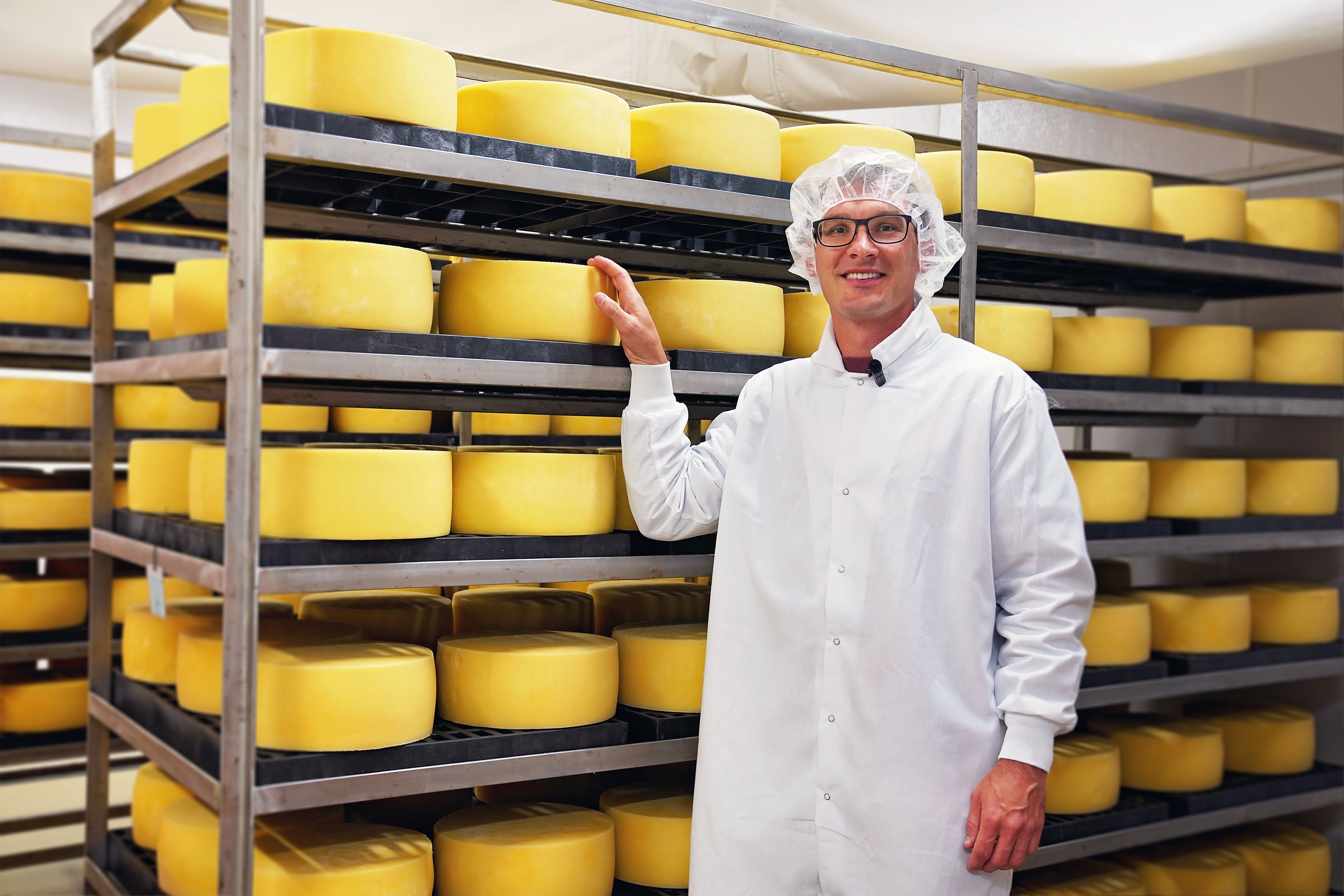 Ferndale_Farmstead_owner_in_front_of_cheese_wheels
