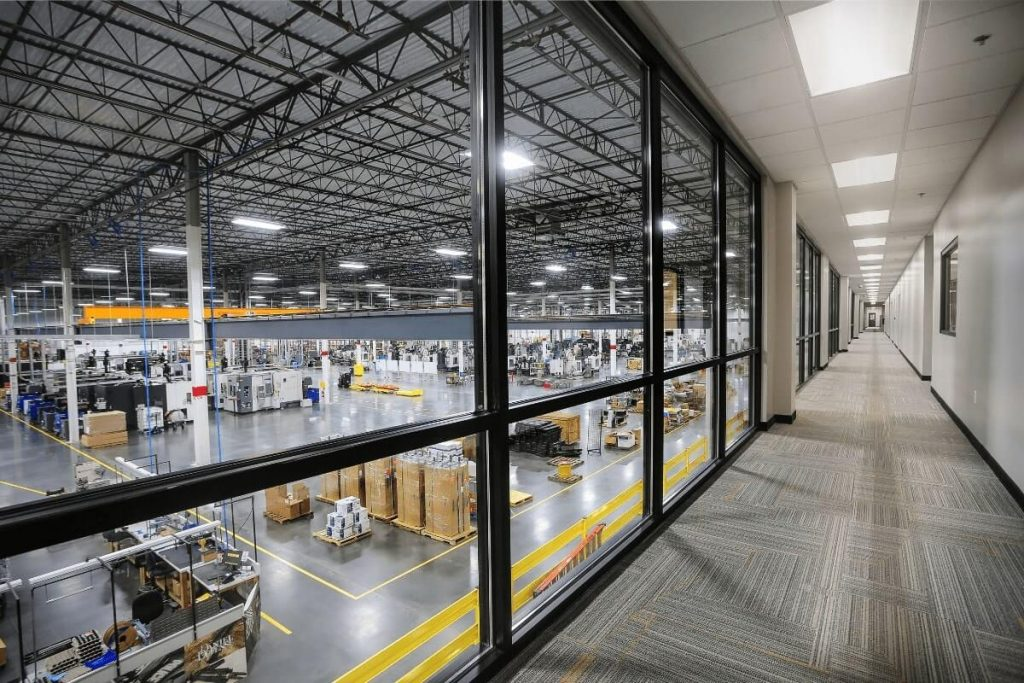 Finished manufacturing plant floor seen through the windows of an upstairs corridor