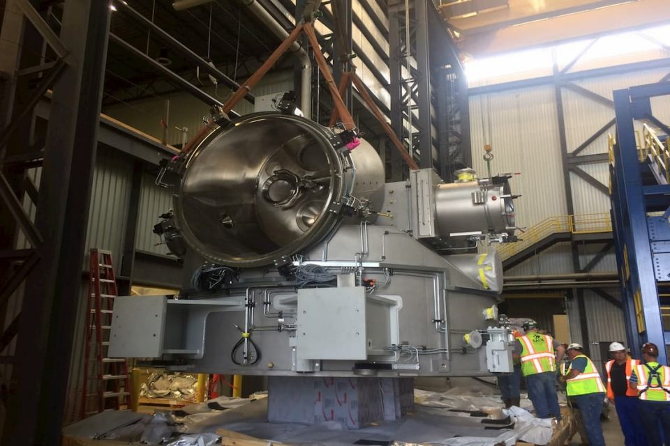 Sack Company crew setting a large stainless steel process machine inside an industrial plant