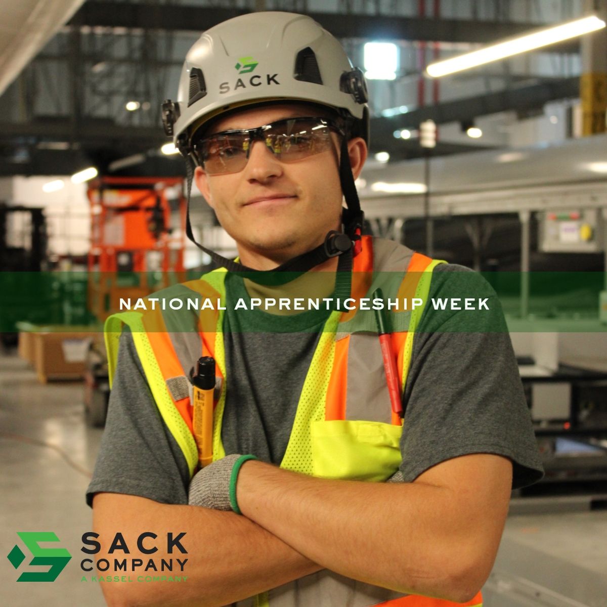Apprentice wearing safety gear and Sack Company hard hat during National Apprenticeship Week at industrial jobsite.