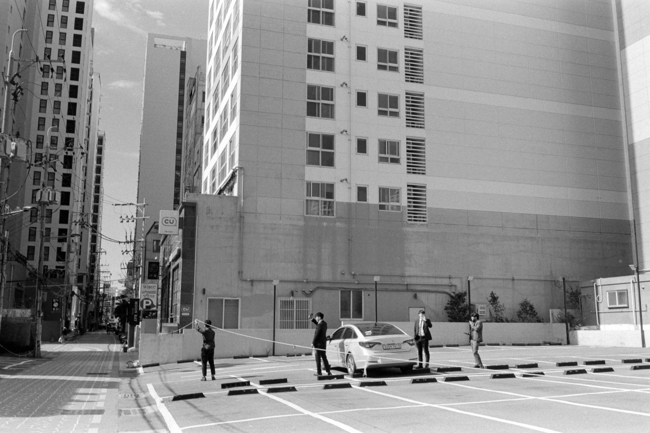 Business men entering a car on a parking lot in Busan