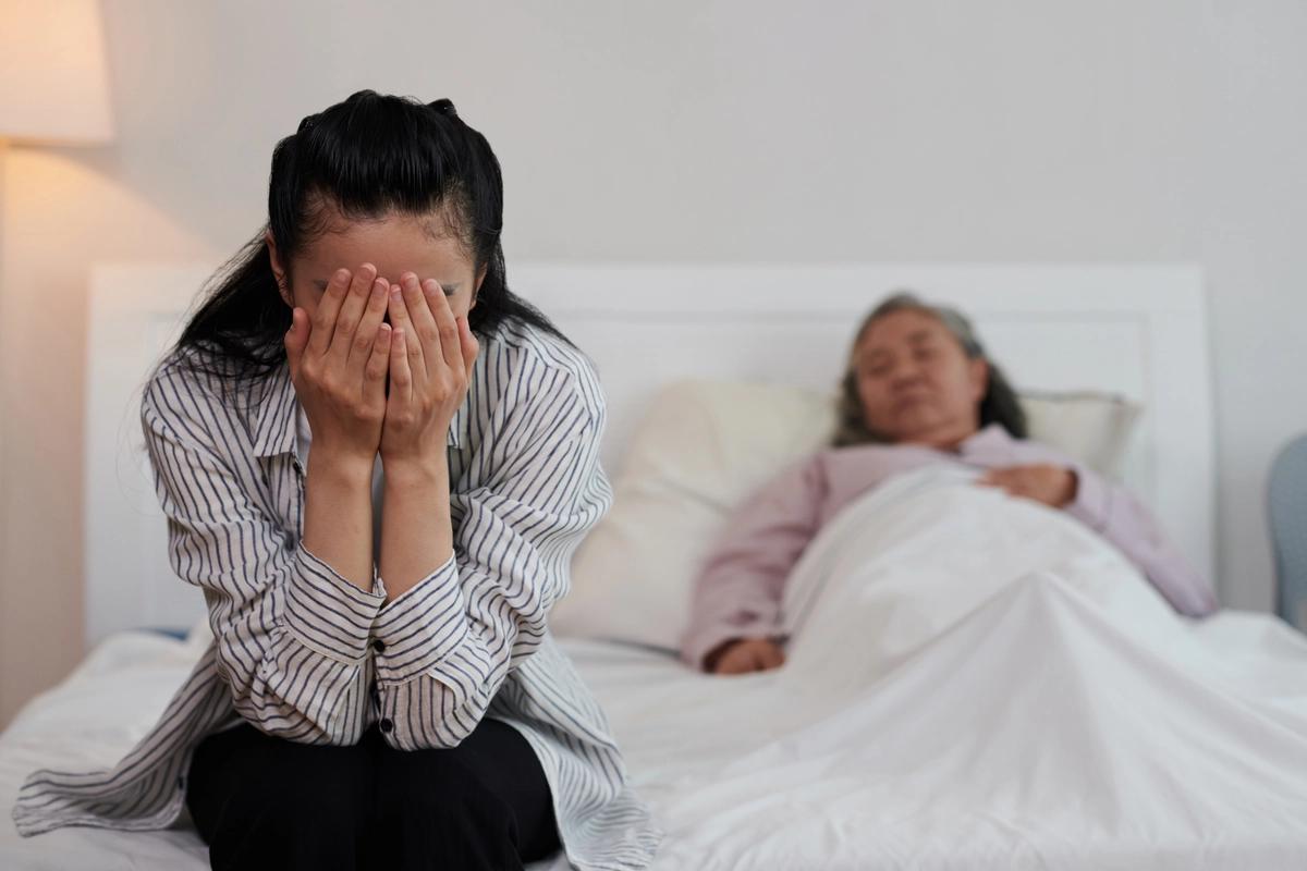 Una hija cuidando de su madre envejeciente y enferma.