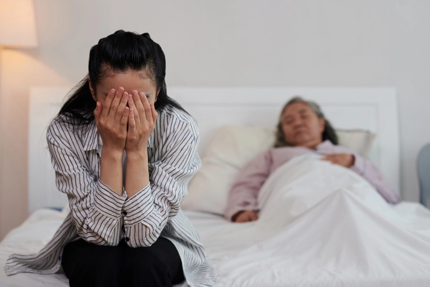 Una hija cuidando de su madre envejeciente y enferma.