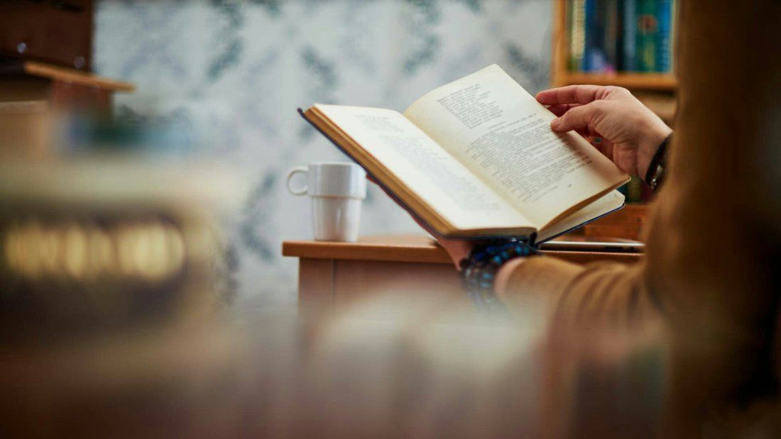 Persona sosteniendo un libro de autoayuda.