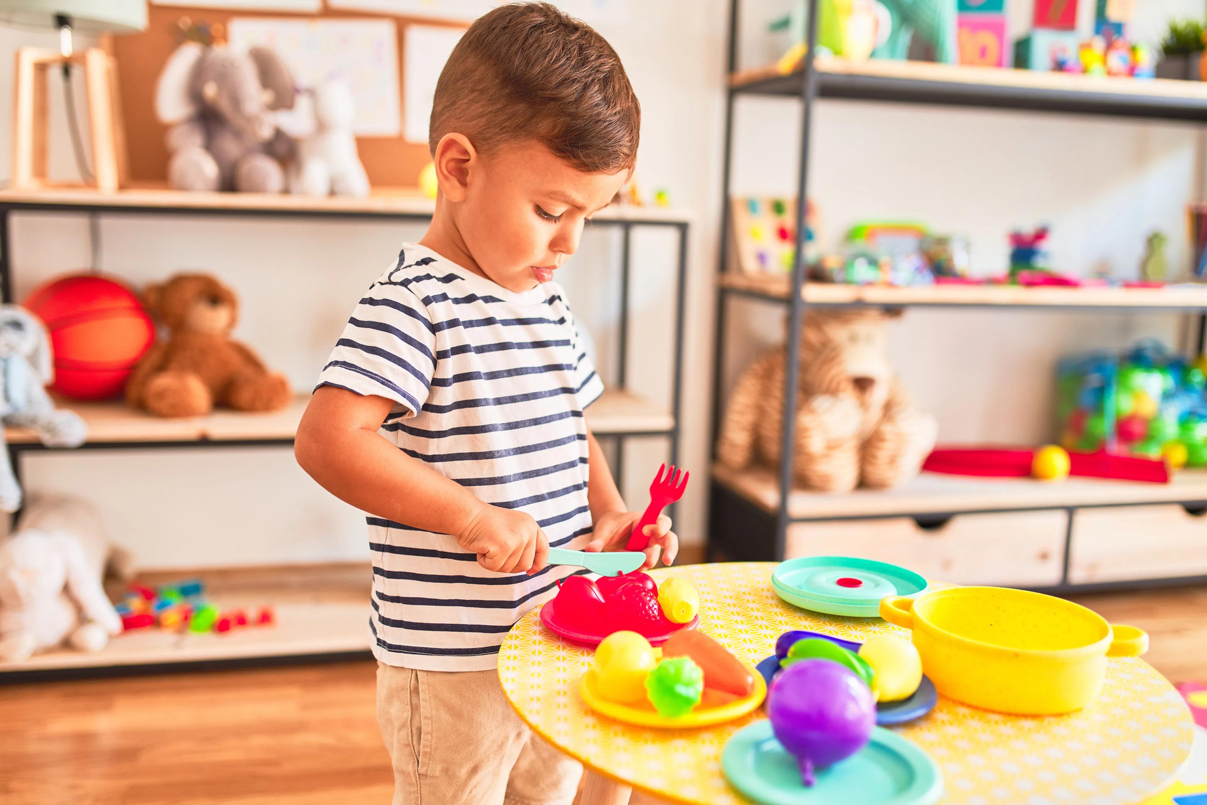 Un niño jugando con juguetes de cocina plásticos.