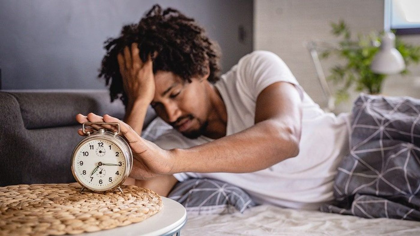 Hombre levantándose después de una noche de insomnio.