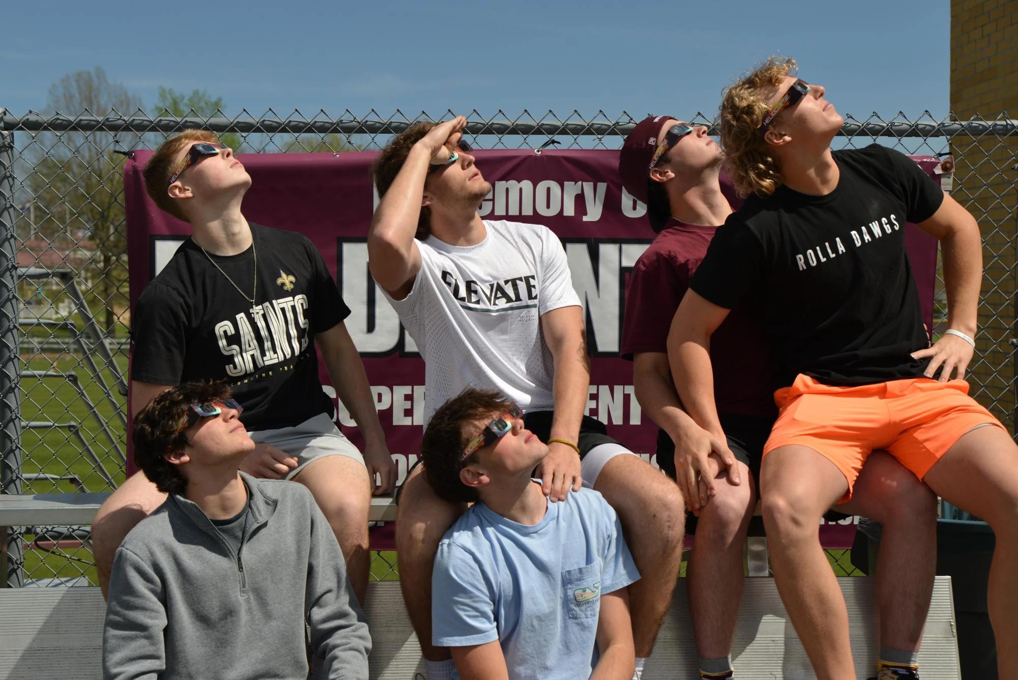 man wearing helioclipse glasses close up looking at solar eclipse — people viewing the eclipse with protective glasses