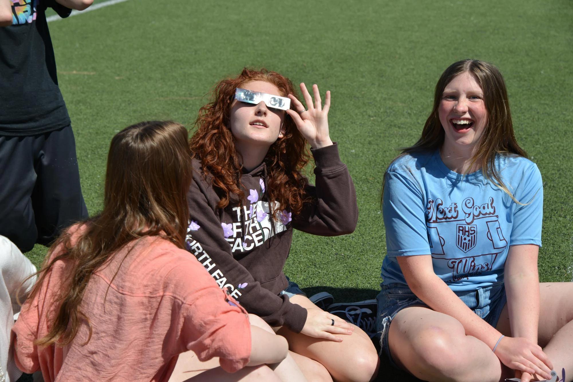 students reacting excitedly to eclipse wearing protective glasses โ people viewing the eclipse with protective glasses