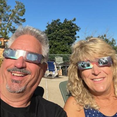 family selfie wearing solar eclipse glasses backyard viewing — people viewing the eclipse with protective glasses