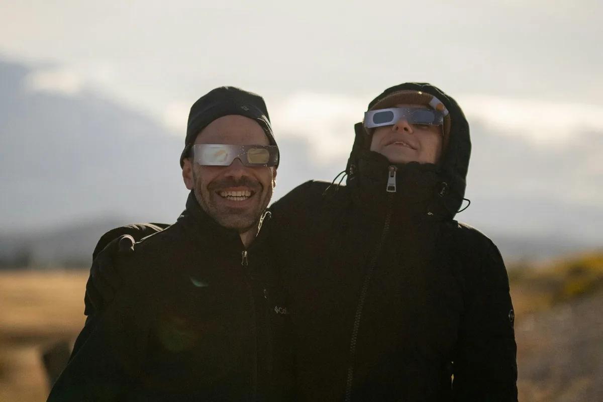 Fólk með myrkvagleraugu undirbýr sig fyrir að fylgjast með sólmyrkva.