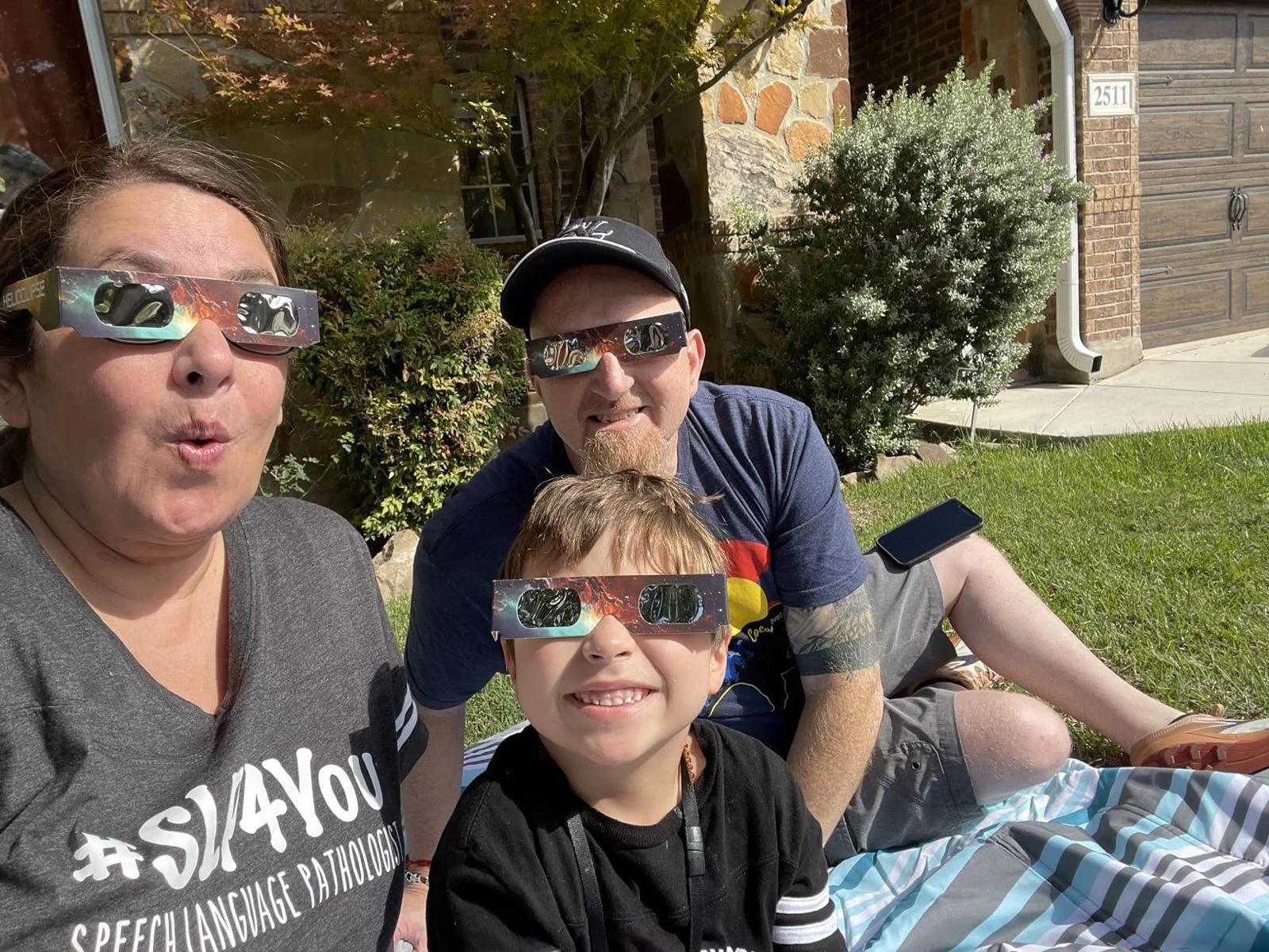 family outdoor picnic watching solar eclipse glasses front yard — people viewing the eclipse with protective glasses