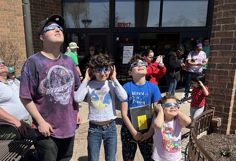 Crowd gathers to watch the solar eclipse outside the Homewood library - HF Chronicle