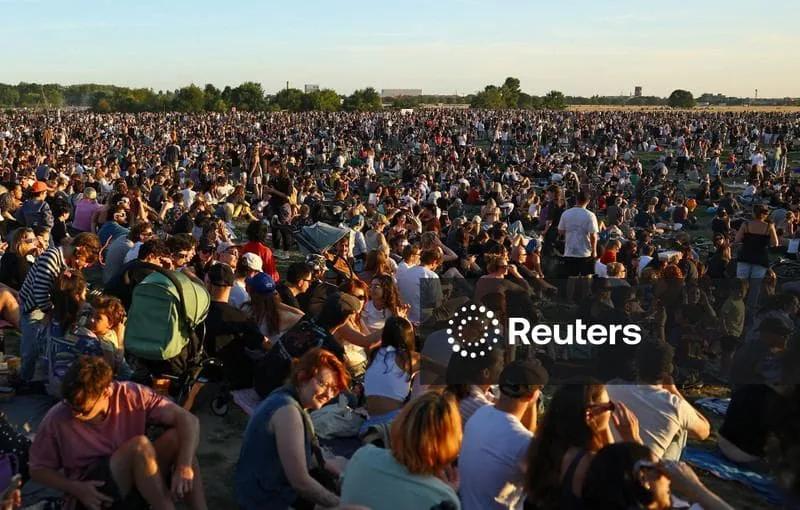 Licensable picture: People watch the partial solar eclipse at Tempelhofer  Feld in Berlin | Reuters Connect