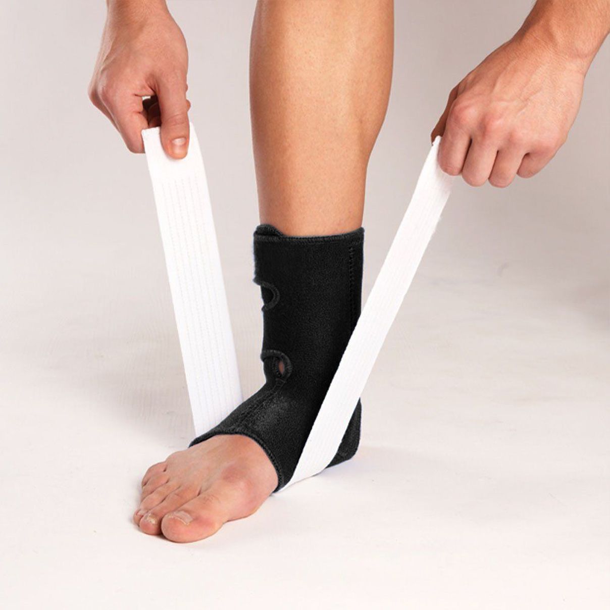 Model fastening the straps of the LP Support 775 Ankle Support