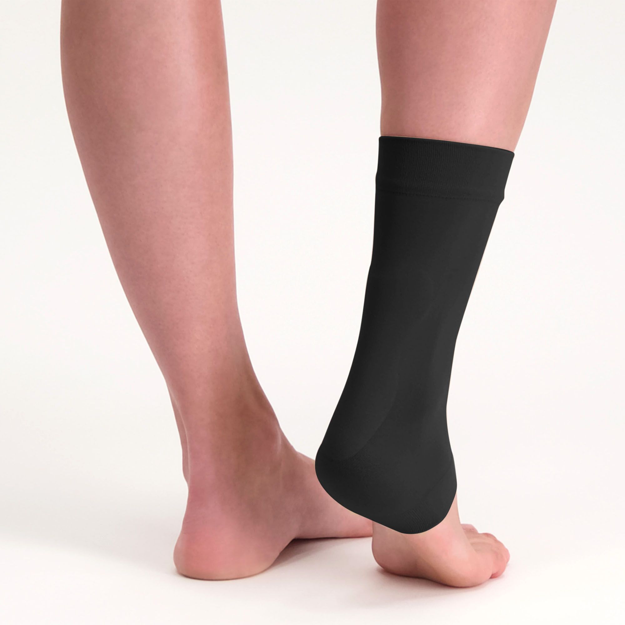 Solelution achilles tendon gel sock black worn around the right foot shown from the back