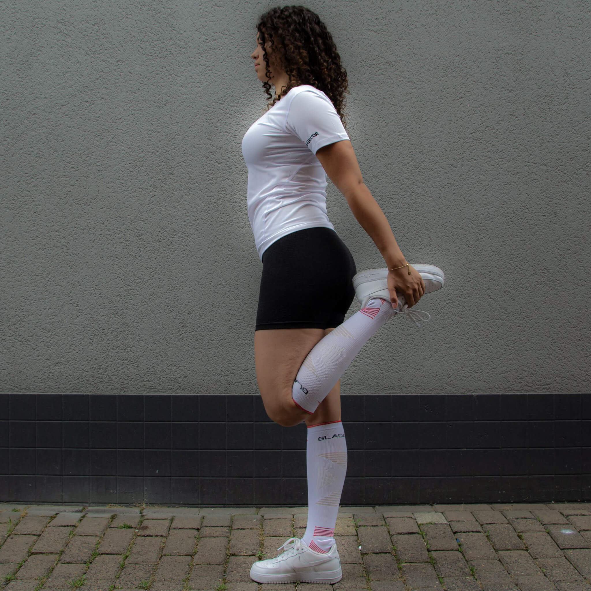Model wearing the Gladiator Sports Ski Socks in White while warming up