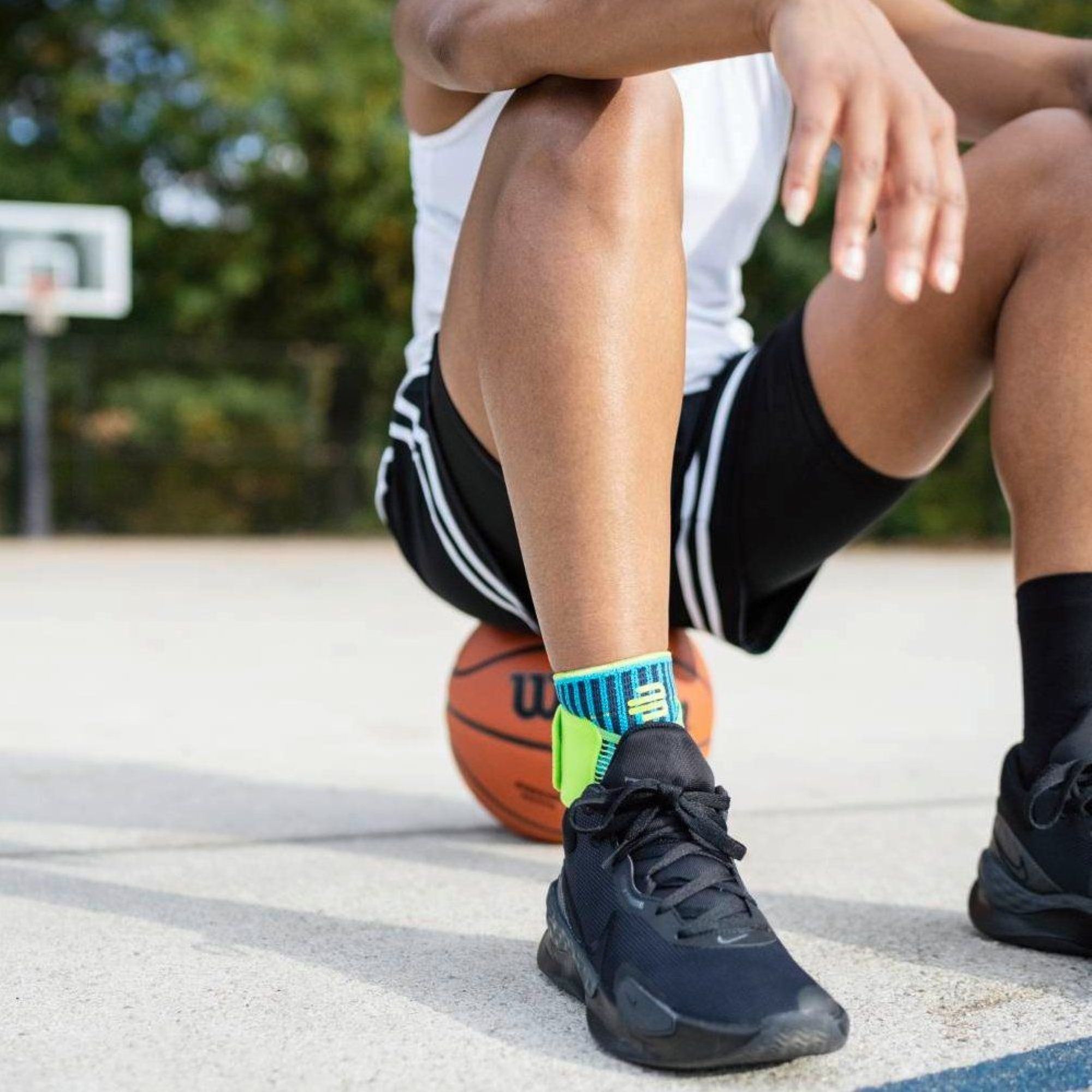 Model wearing the Bauerfeind Sports Ankle Support while playing basketball