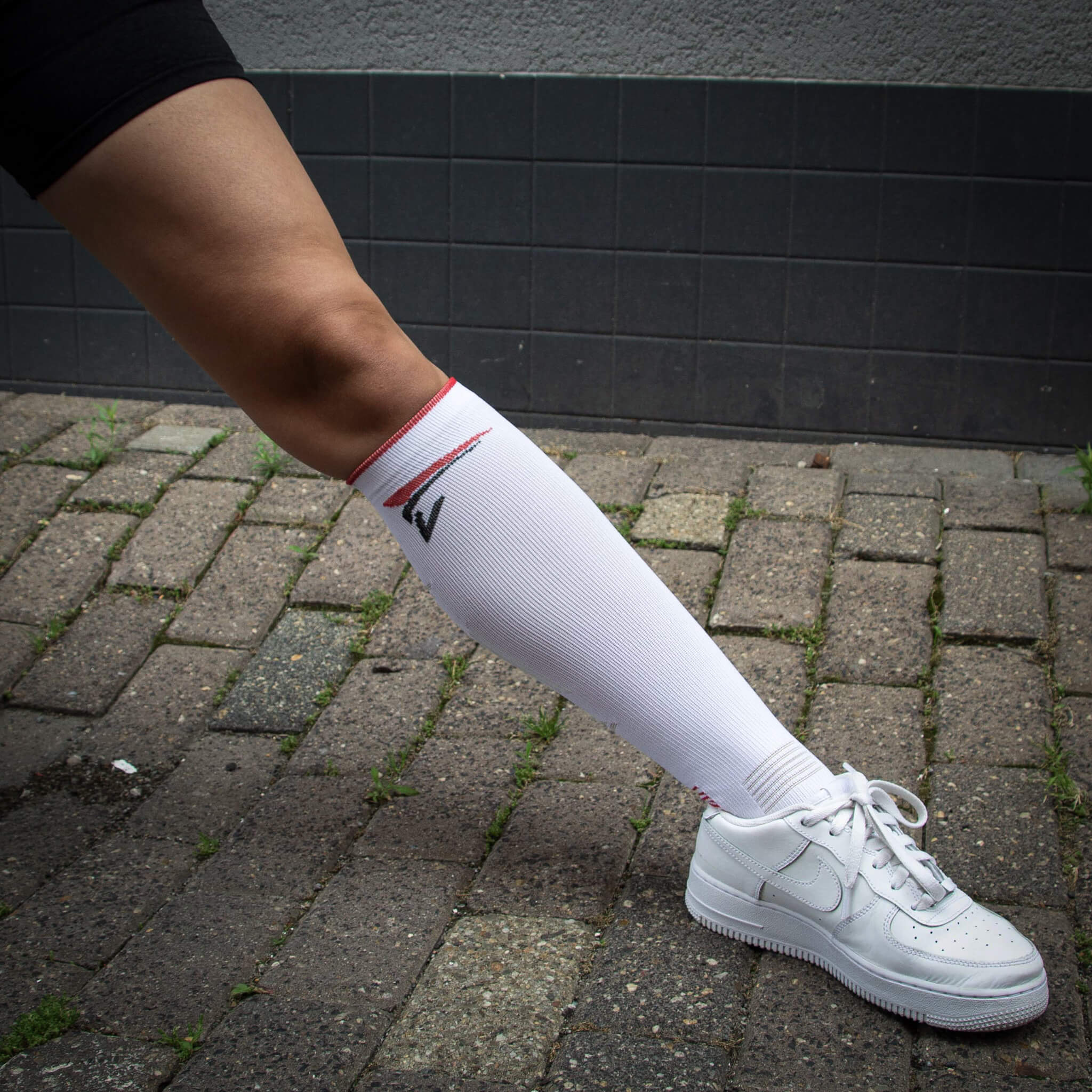 Model wearing the Gladiator Sports Ski Socks while stretching one leg