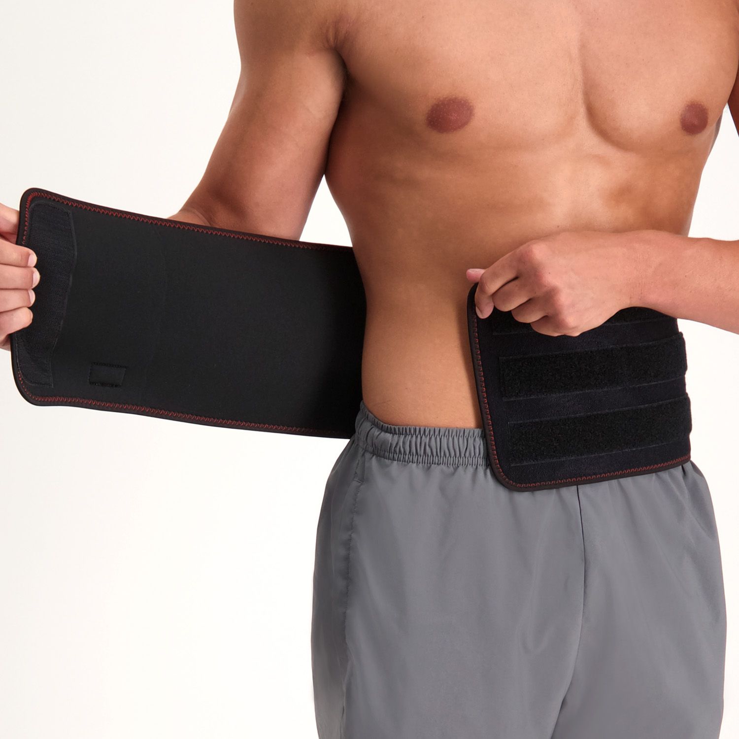 Male model putting on the Gladiator Sports Back Support