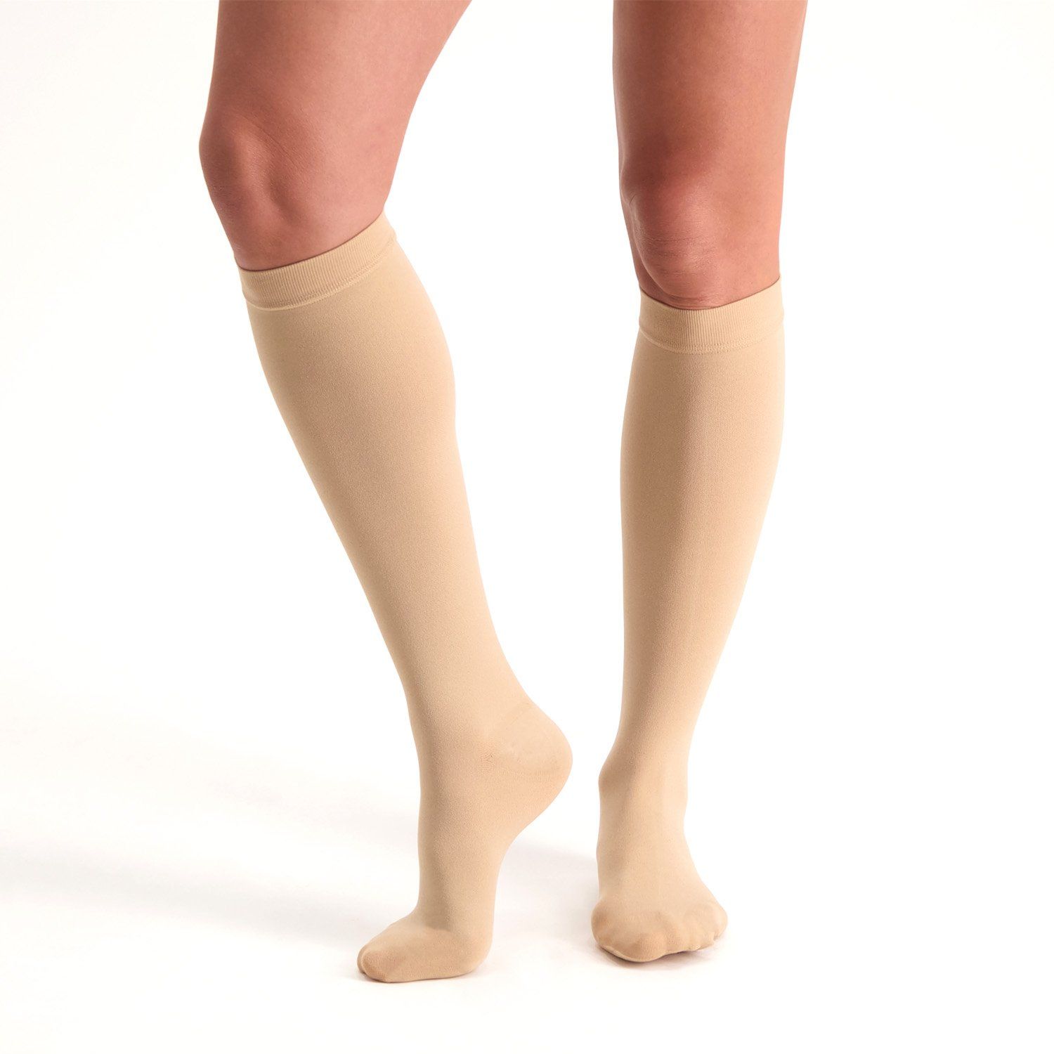 dunimed premium comfort compression stockings short closed toe in beige worn by model on both legs with the right foot lifted up slightly