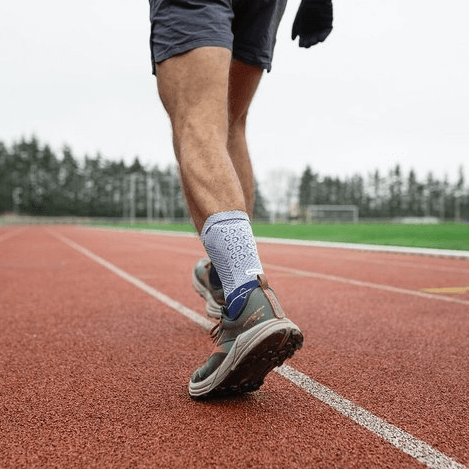 Model wearing the Bauerfeind AchilloTrain - Achilles Tendon Support in his shoe while running