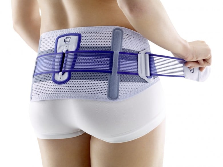 Model putting on the Bauerfeind Sacroloc Back Support - Pelvic Belt