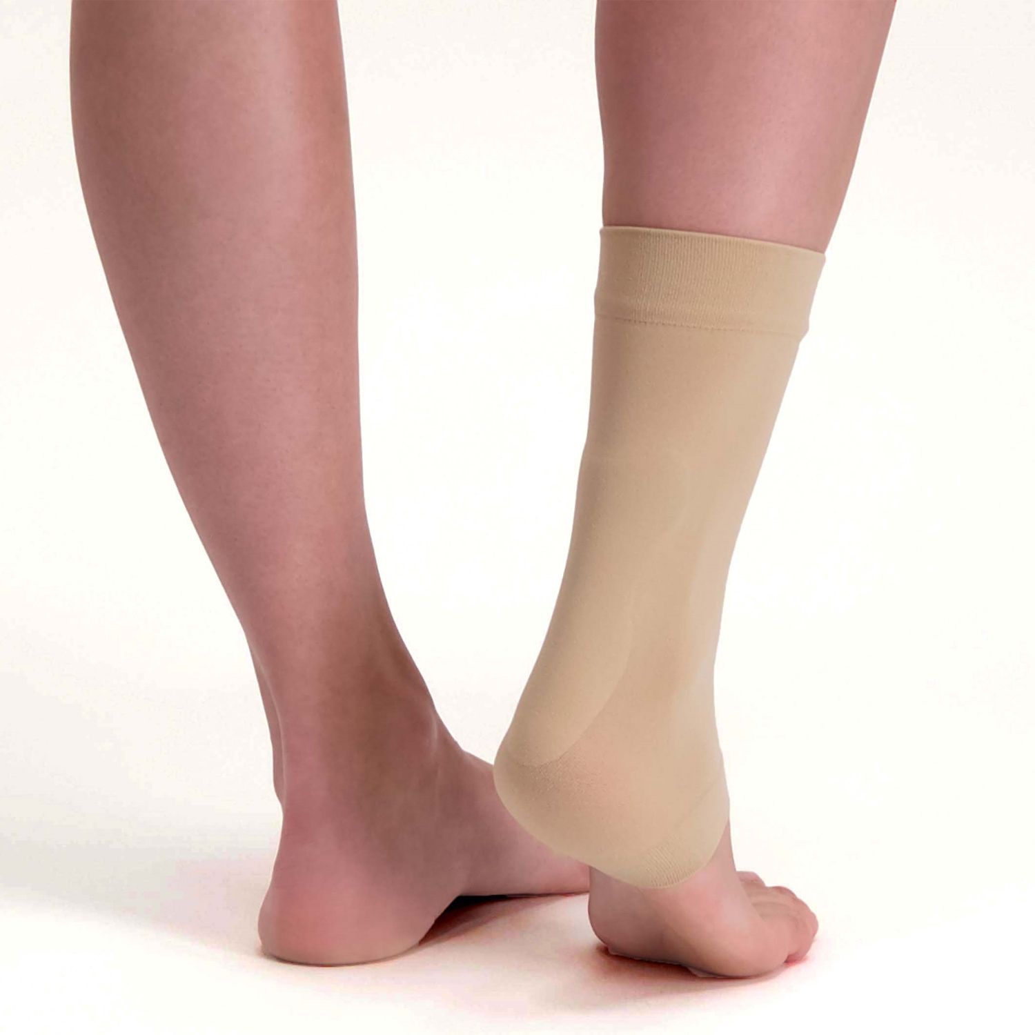 Back view of model wearing the Solelution Achilles Tendon Gel Sock - Beige while lifting the ankle up