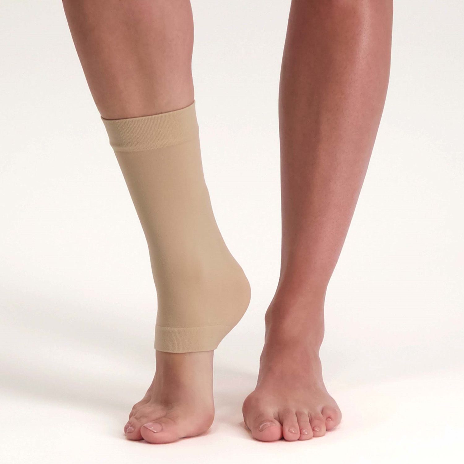 Left side view of model wearing the Solelution Achilles Tendon Gel Sock - Beige around the right ankle