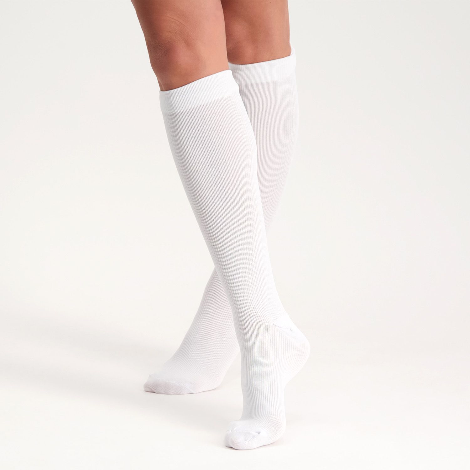 Front view of model wearing the Support Stockings / Travel Stockings - Closed Toe - White while walking