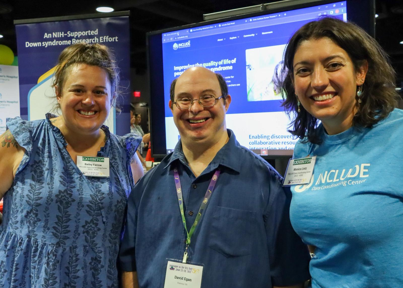 INCLUDE DCC team members standing with self-advocate at the INCLUDE DCC booth