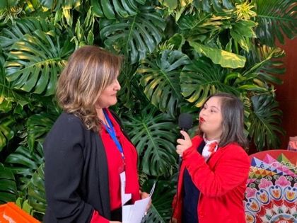 Image of a person with Down syndrome interviewing INCLUDE team member Linda Garcia