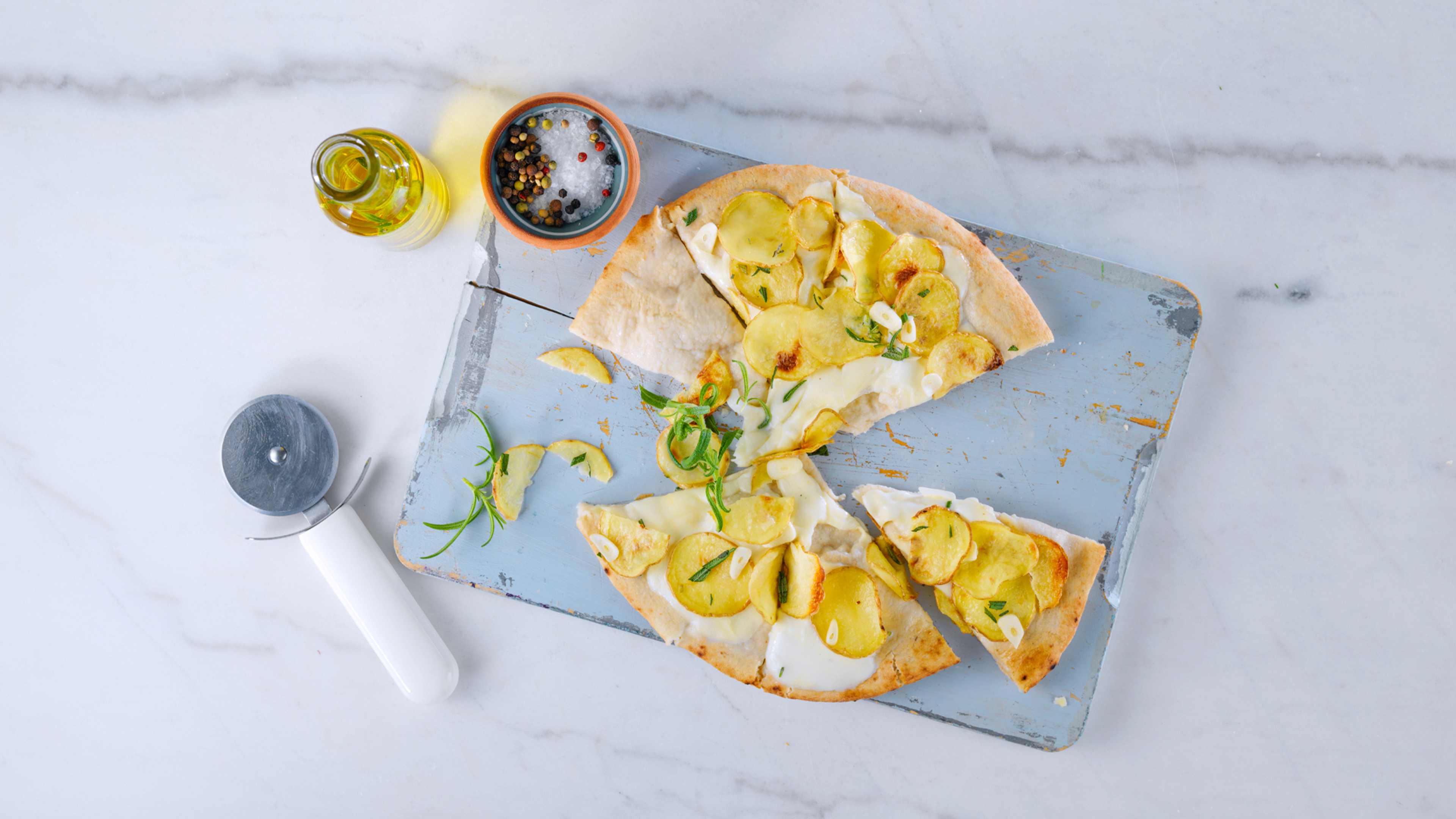 middag med fem ingredienser i form av en pizza med hvit bunn dandert på fat