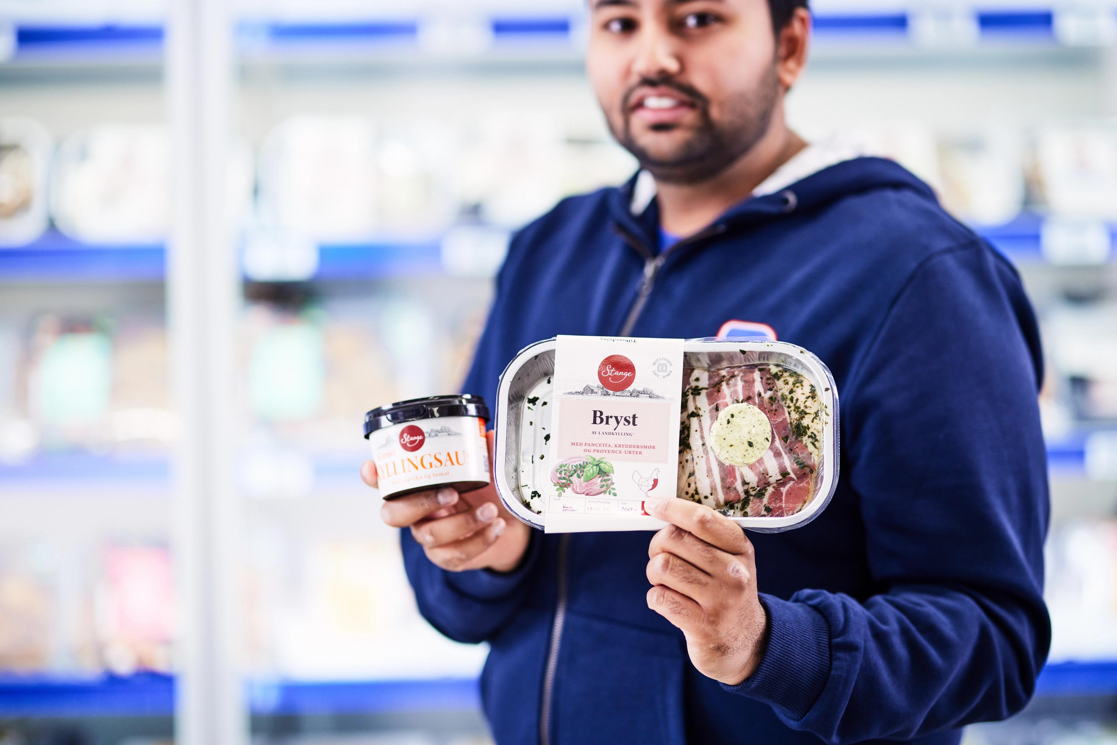 Rema ansatt som holder to stangeprodukter i hånda; bryst og saus