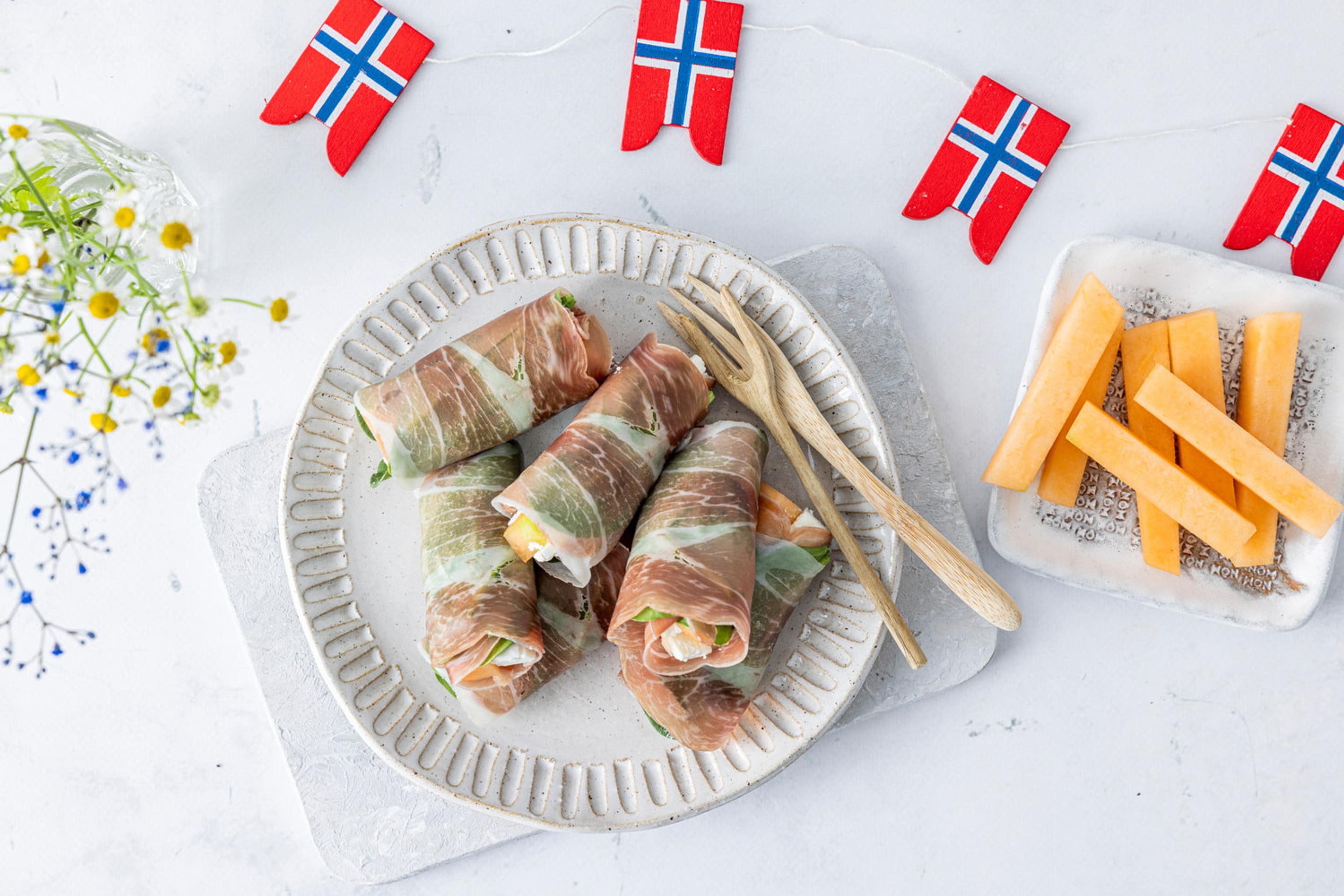 Tapasbord dekket med spekeskinkruller og fat med melon.