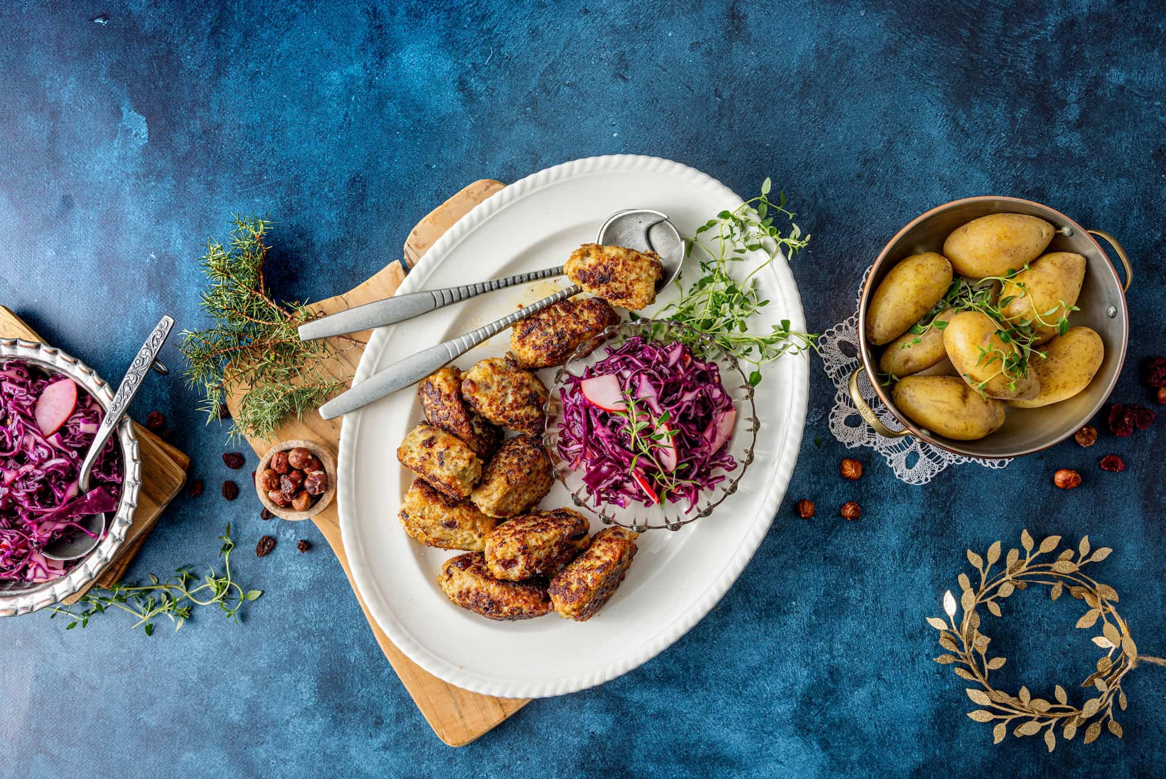 Medisterkaker med tørkede frukter på et hvitt fat.