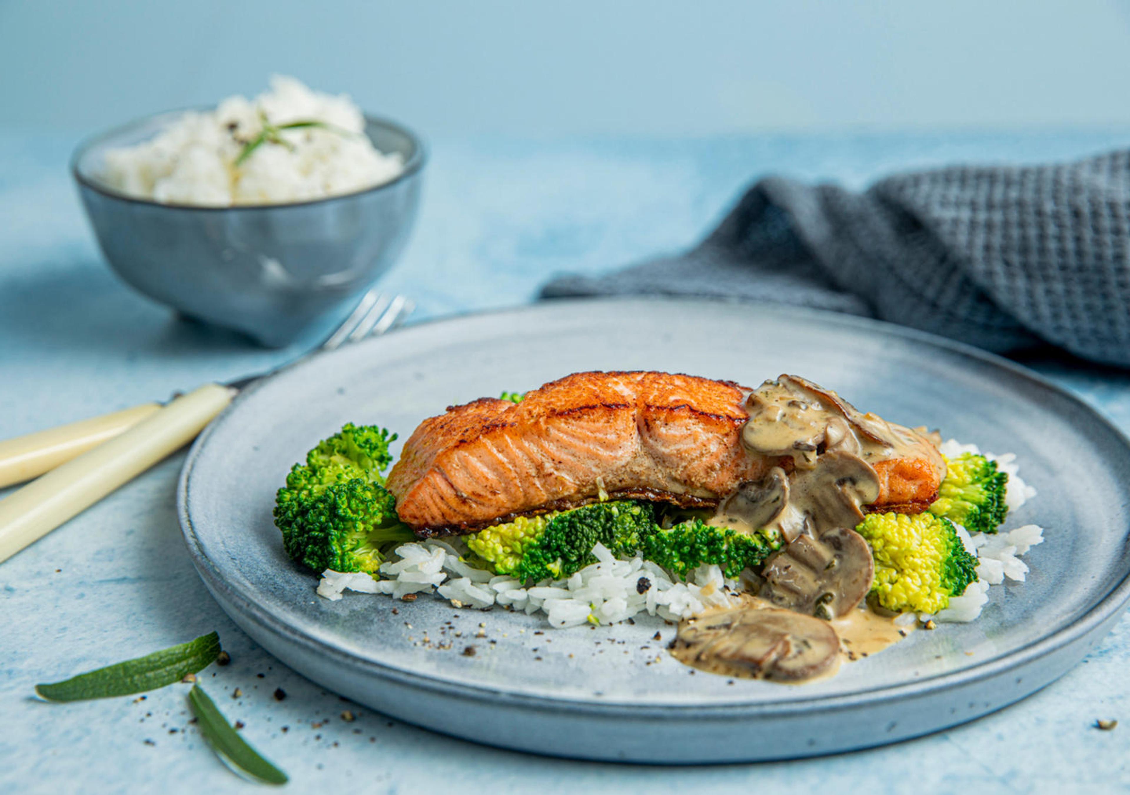 Ørret med kremet soppsaus og ris, toppet med stekt brokkolig og sjampinjong i skiver.