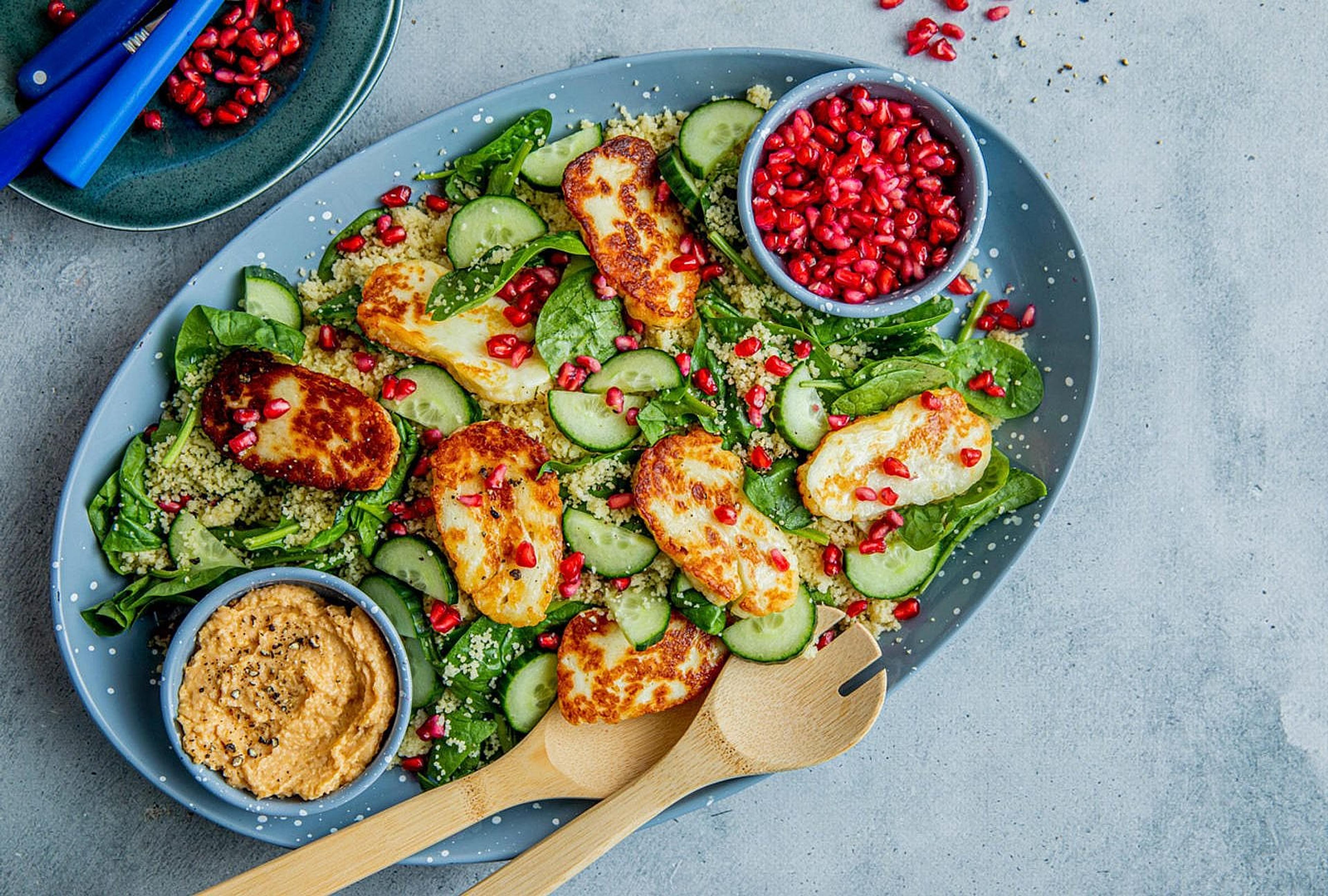Naanbrød toppet med falafel, salat og dressing.