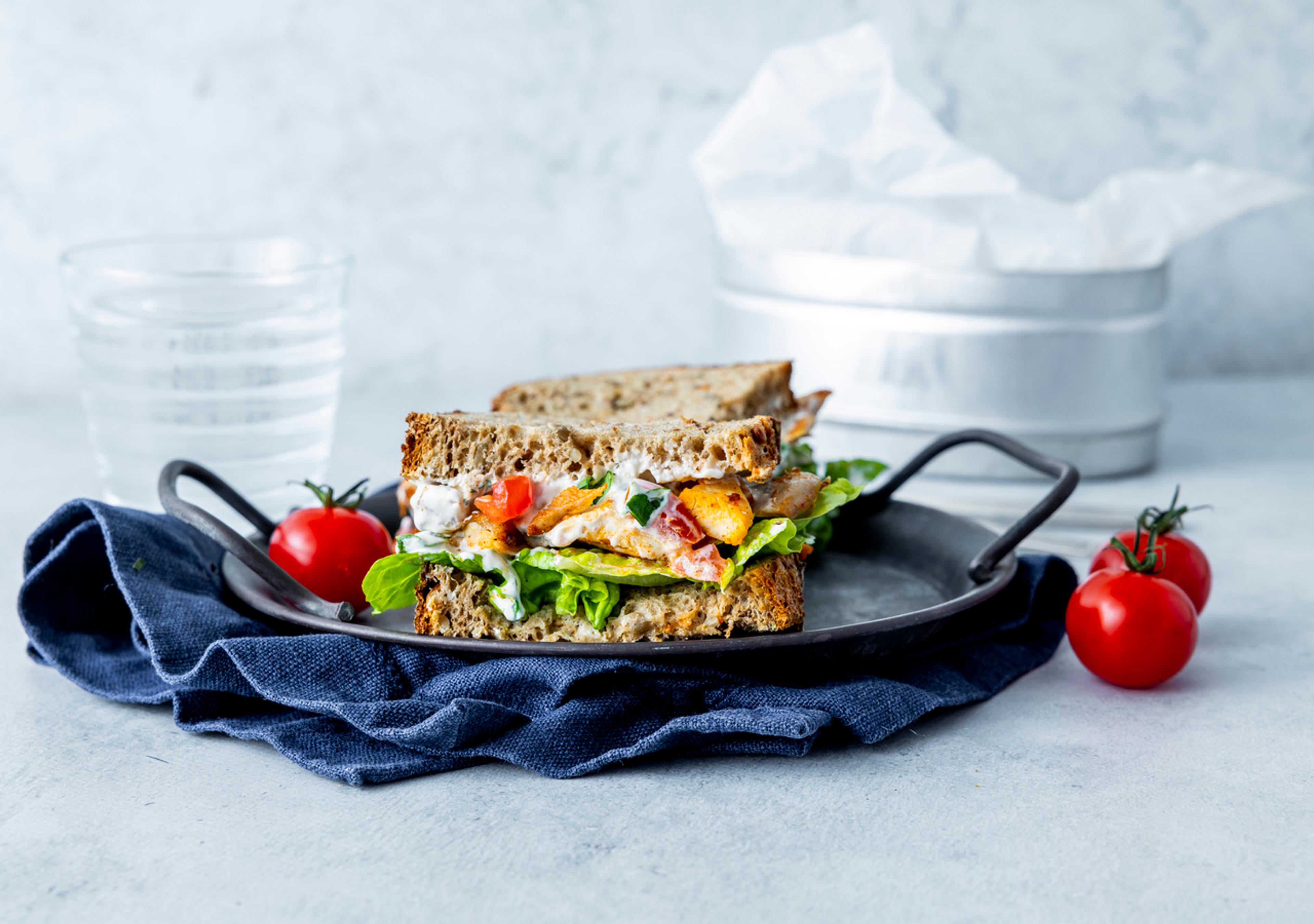 Sandwich med kylling og kremet tomatfyll på en tallerken