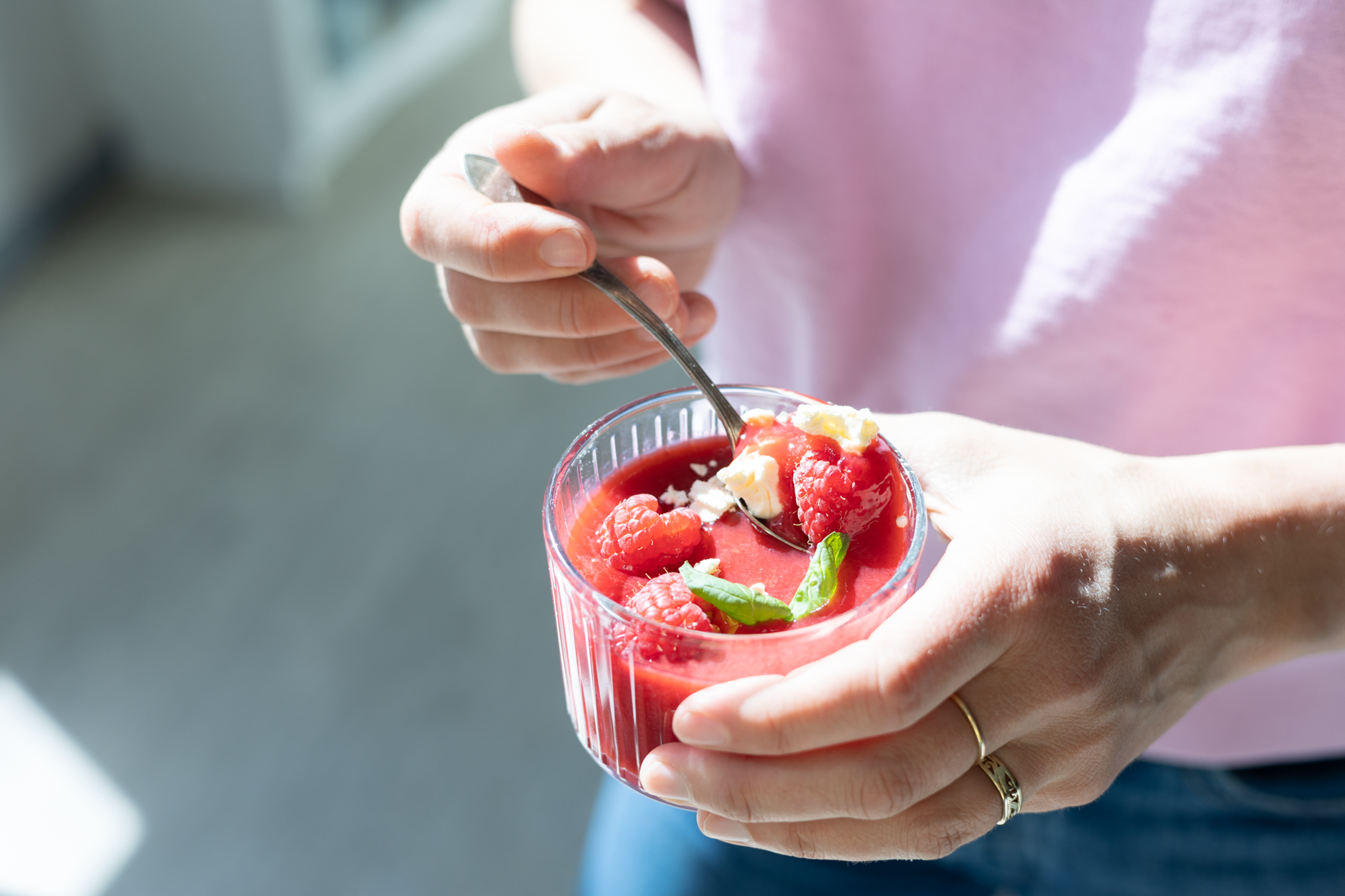 hender som holder en bringebærsuppe i solen