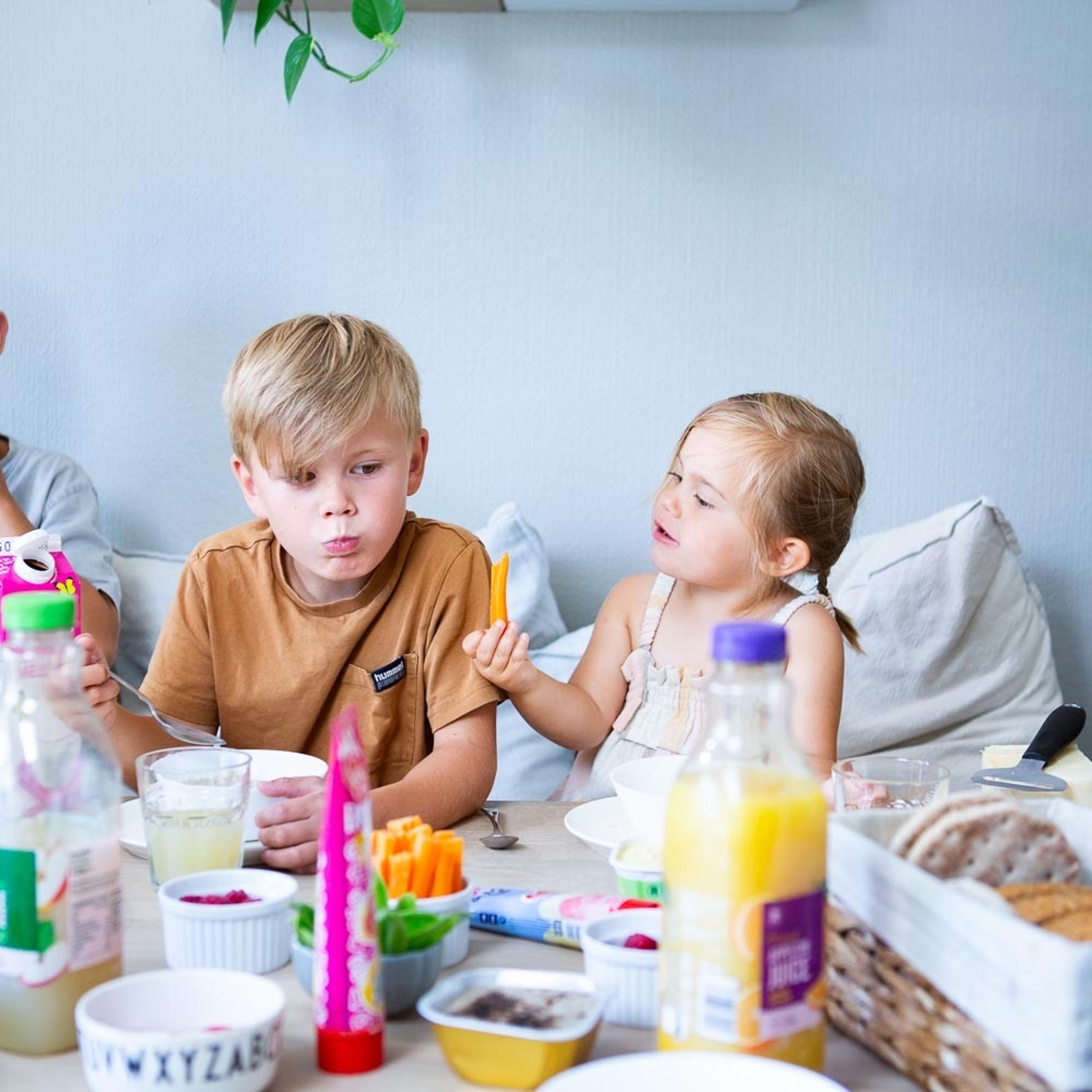 Skolegutt og lillesøster ved frokostbordet