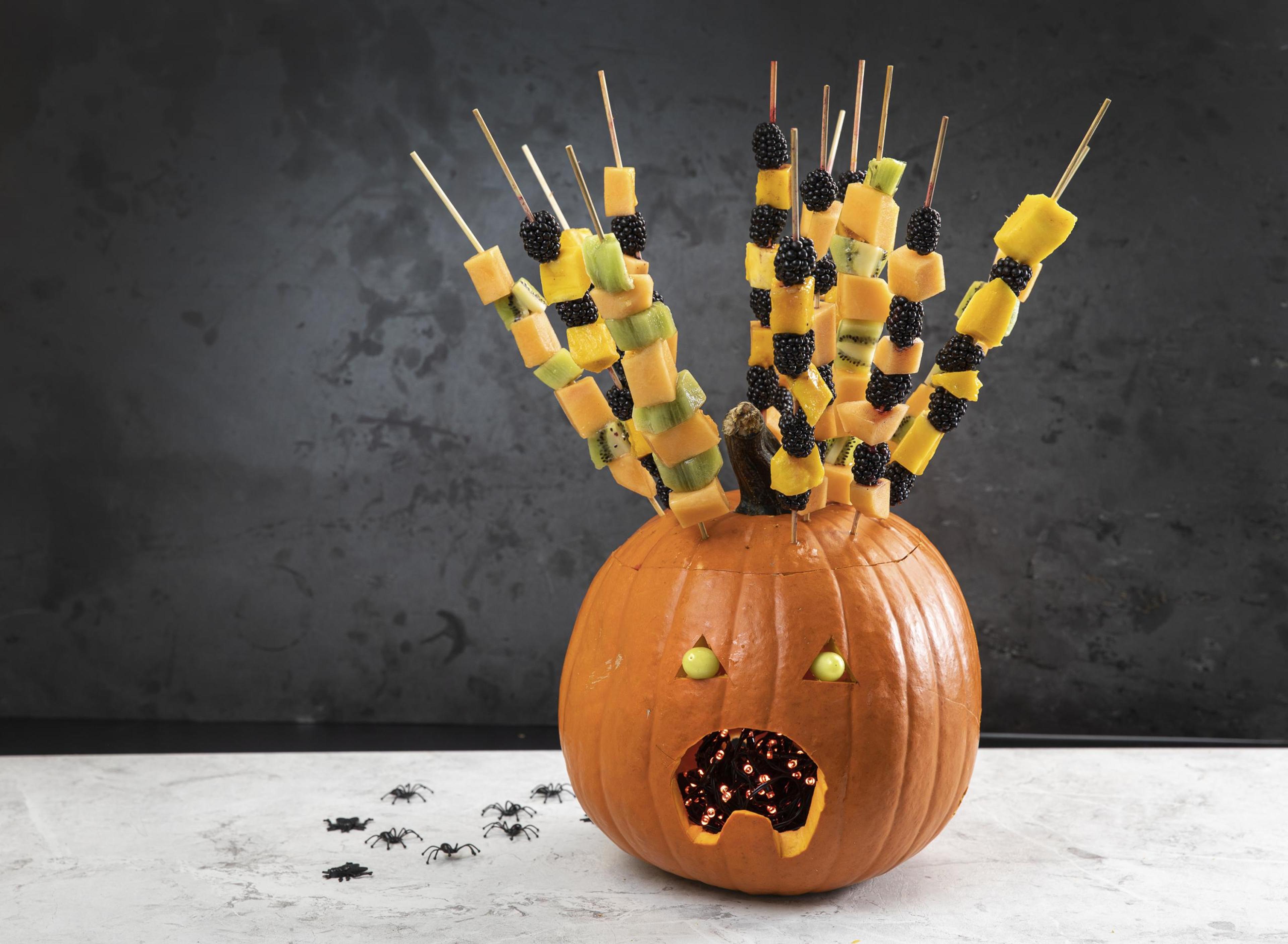 Halloween-gresskar fylt med fruktspyd av melon, kiwi, ananas og bjørnebær.
