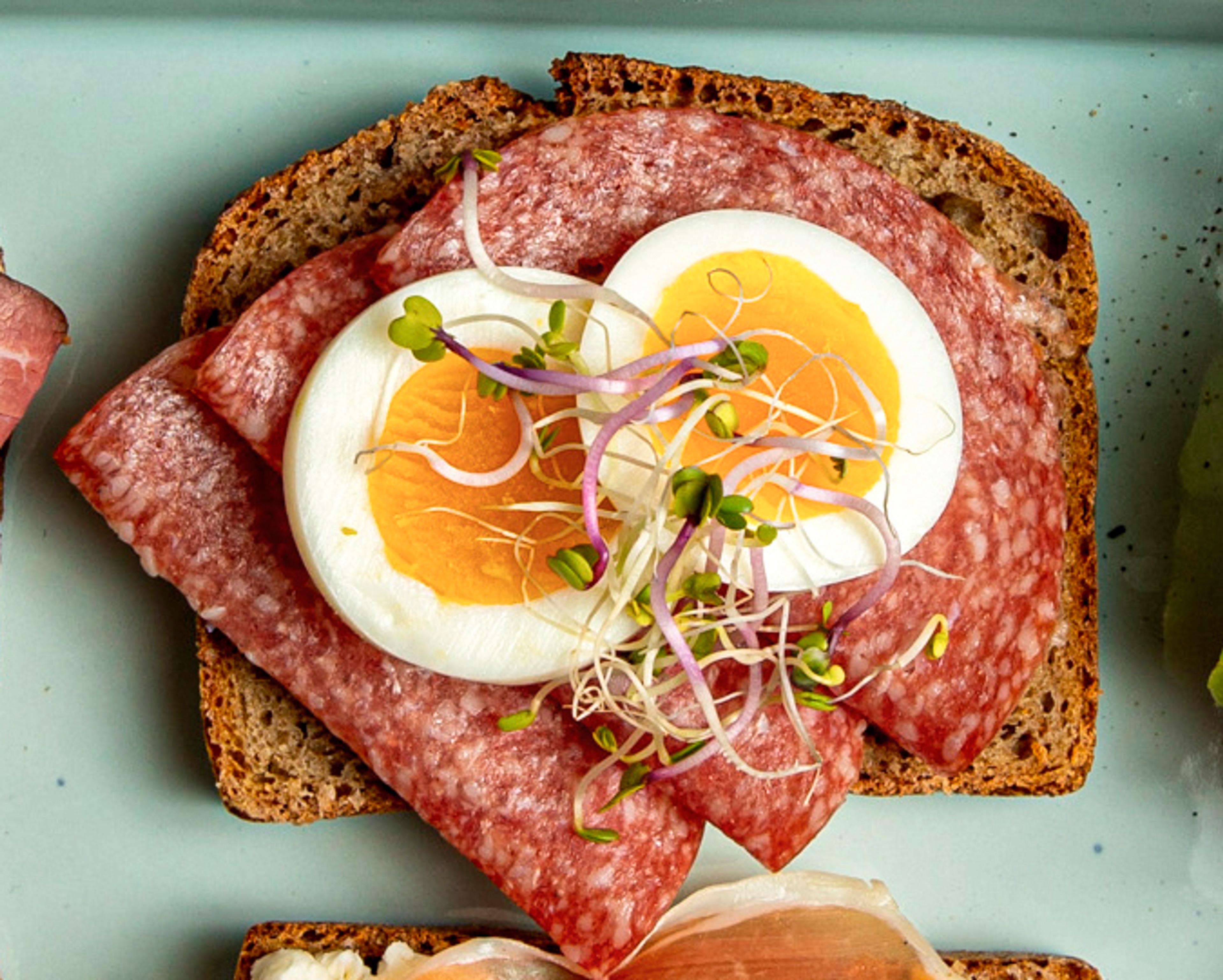 brød med pålegg salami med kokt egg og spirer