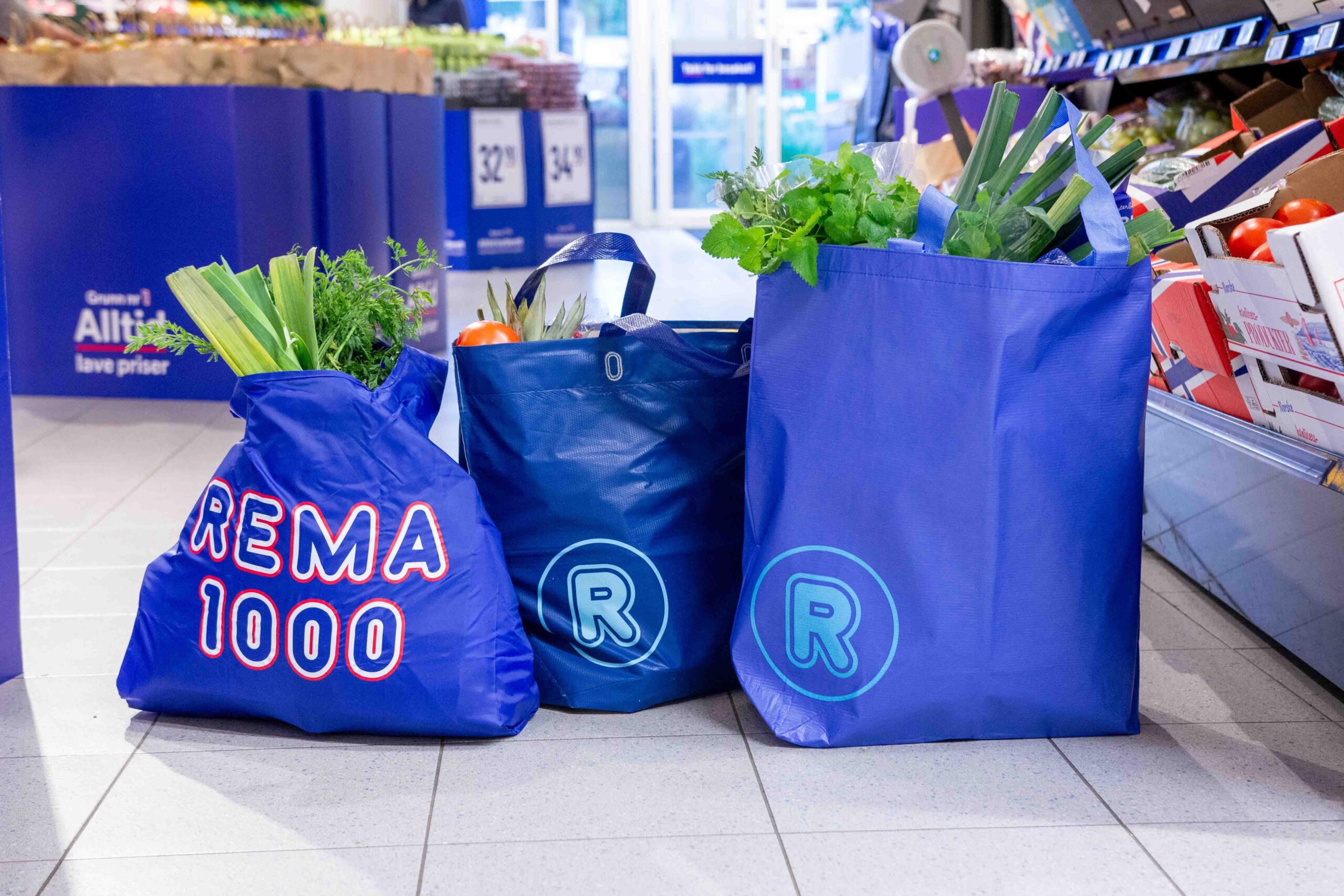 Tre REMA 1000 handleposer fylt med frukt og grønt