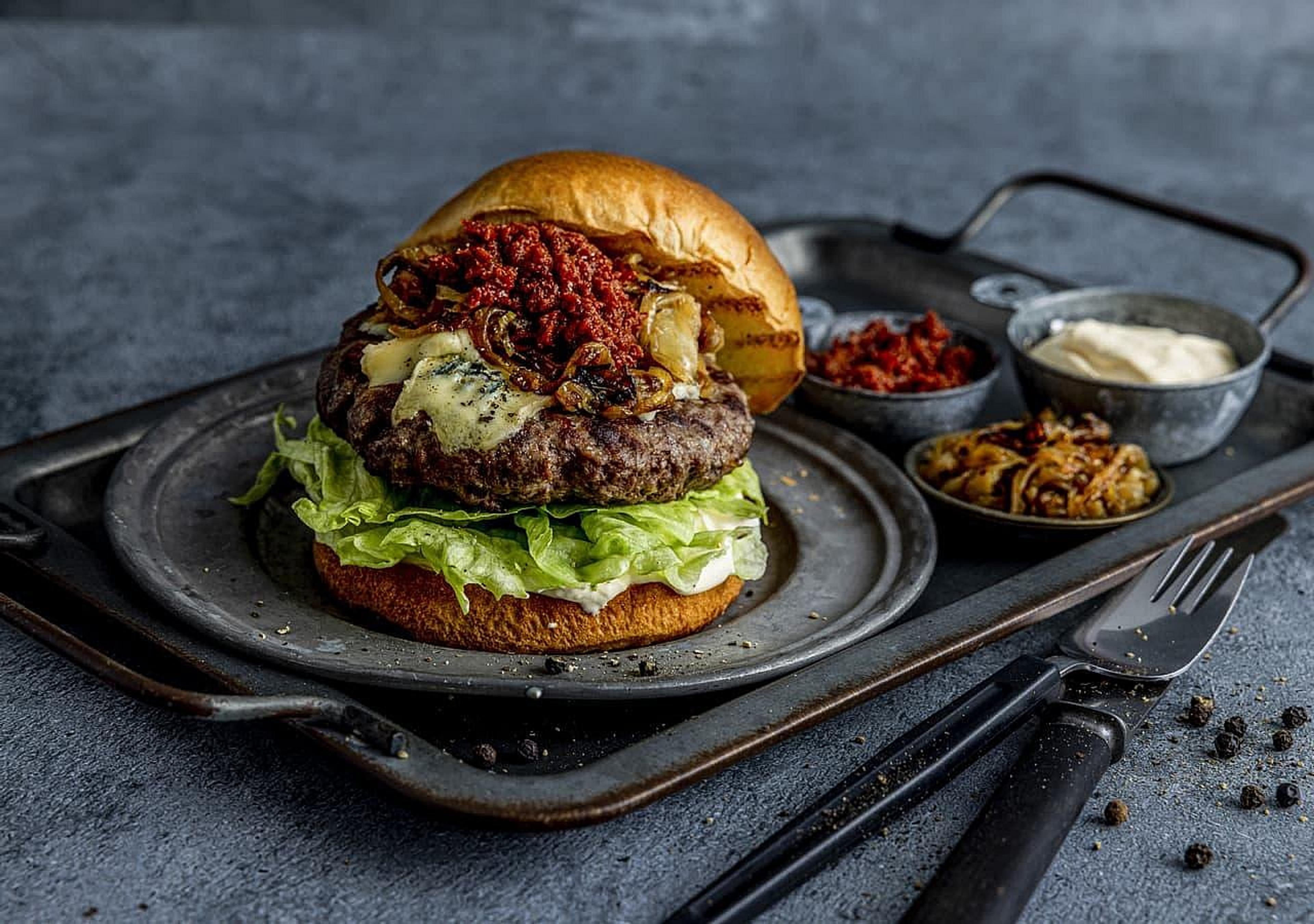 Tallerken med saftig hamburger med salat og blåmuggost