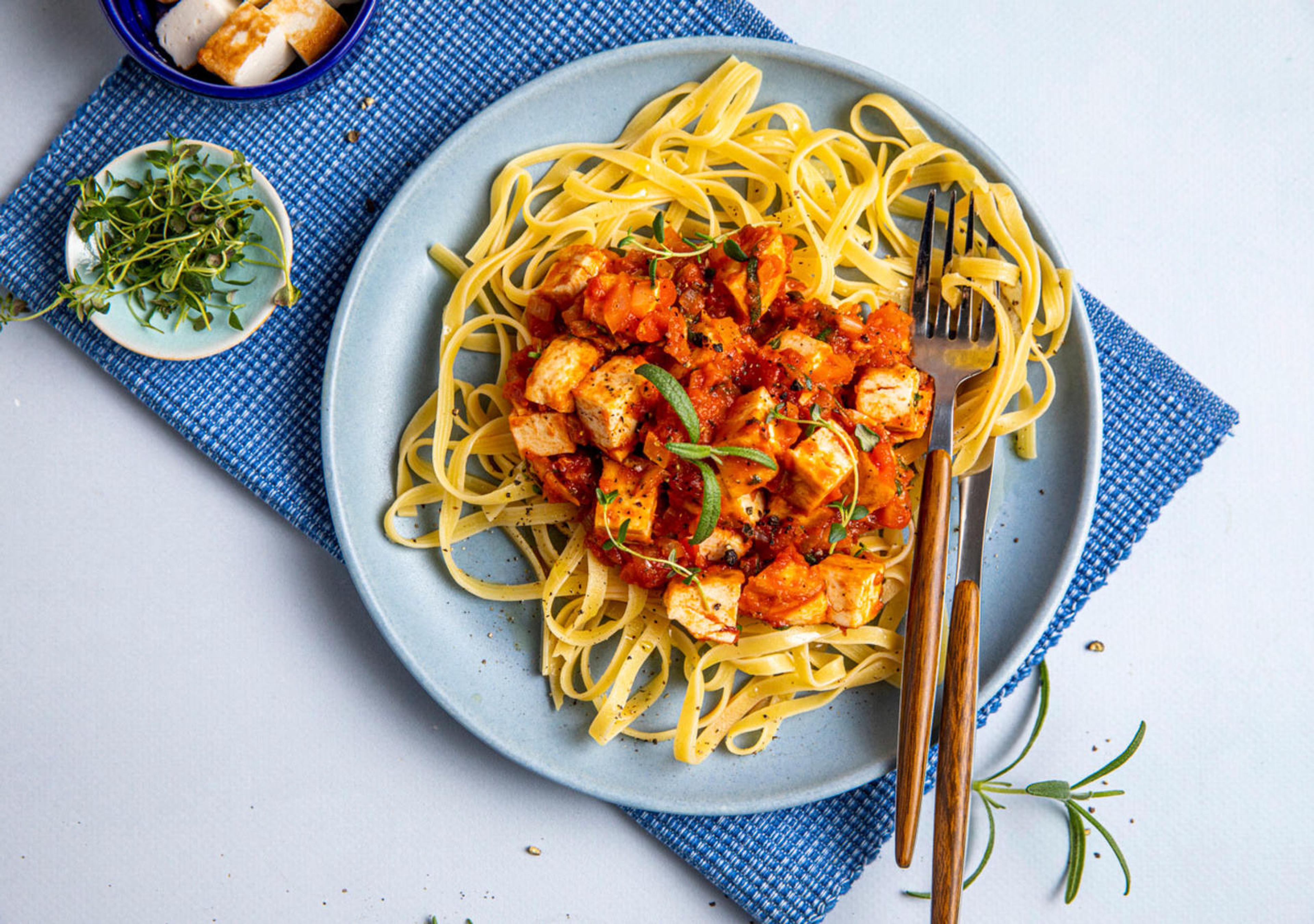 Fiskekaker i biter i tomatsaus og maispasta.