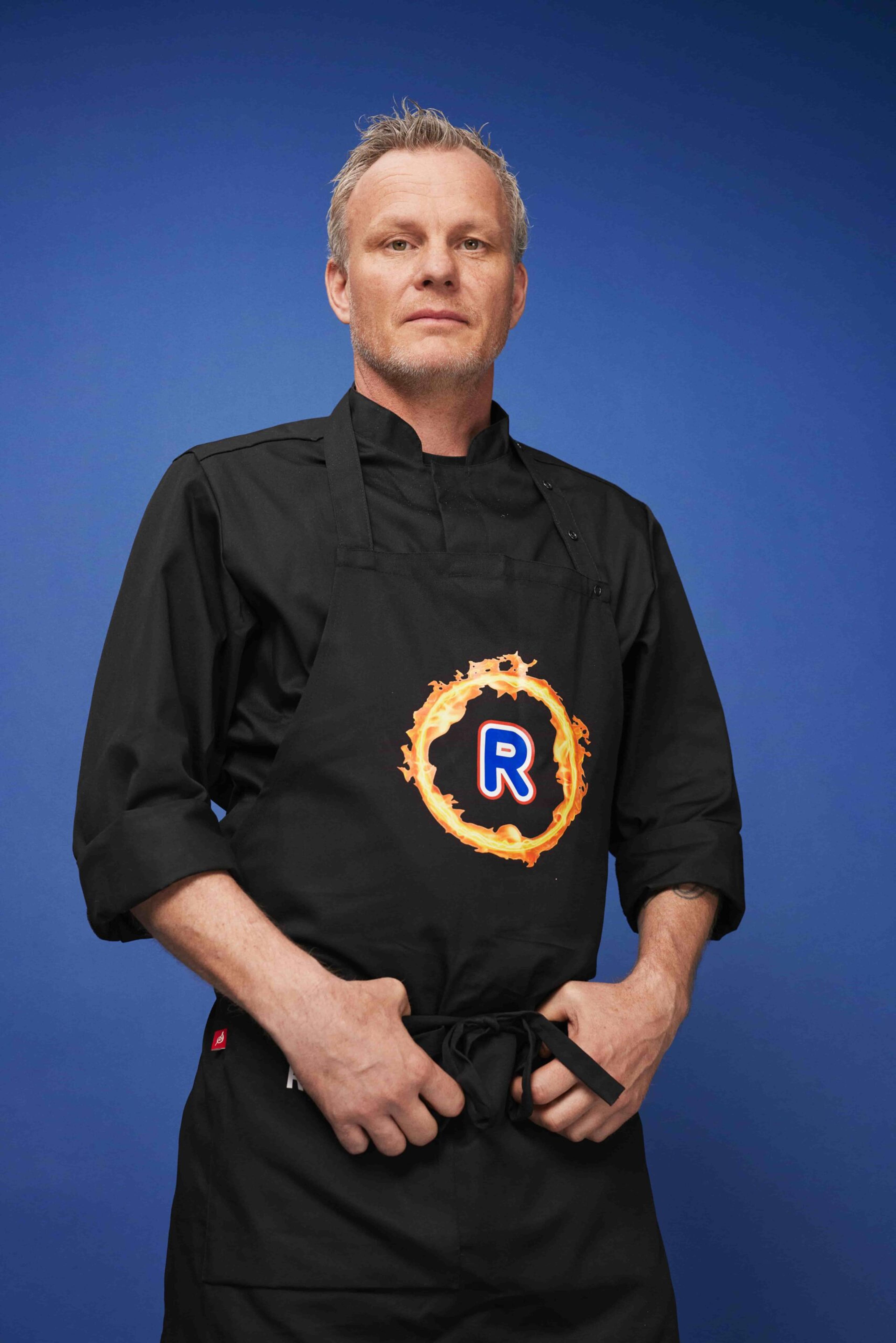 Rune Alexander Nilsen i uniform med Rema R-logo, foran en blå bakgrunn.