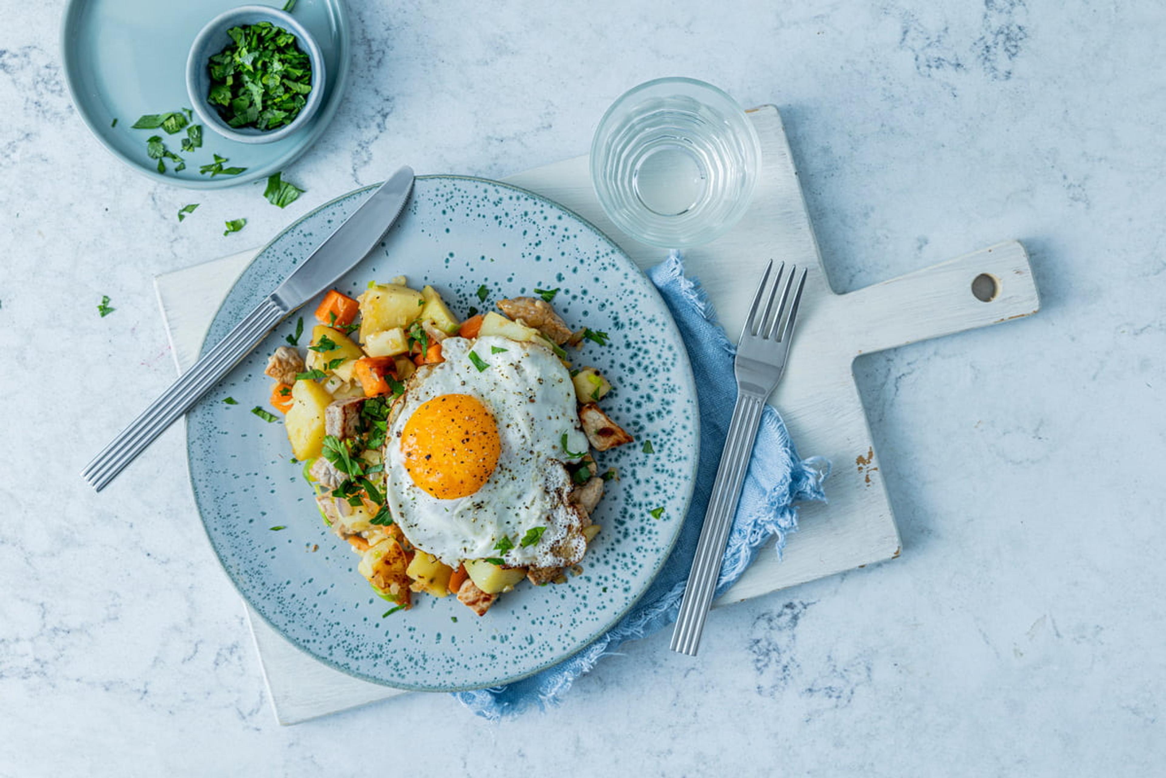 Bilde av pytt i panne med egg på en blå tallerken.