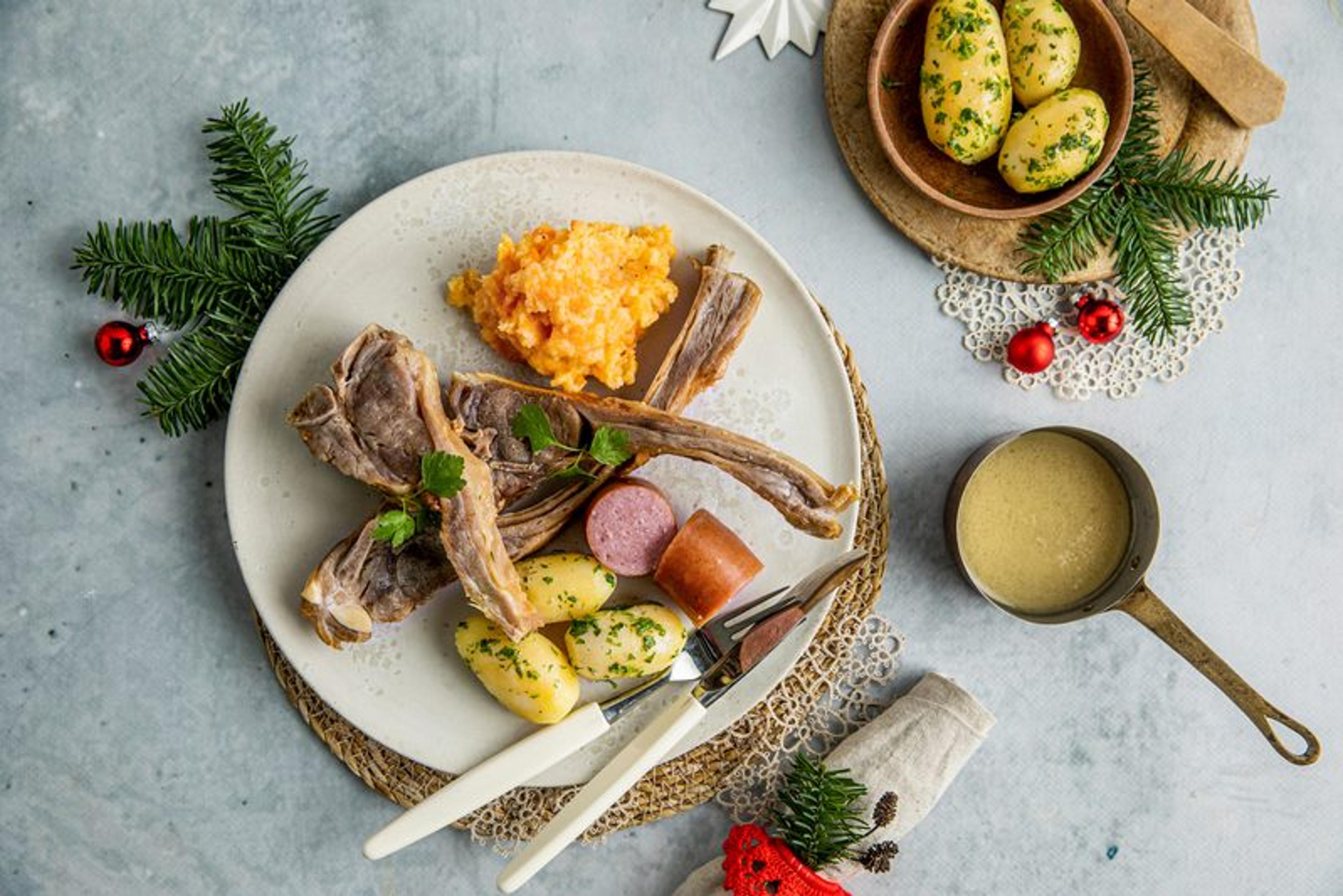 Pinnekjøtt med kålrabistappe, kokte poteter, pølse og sjysaus.