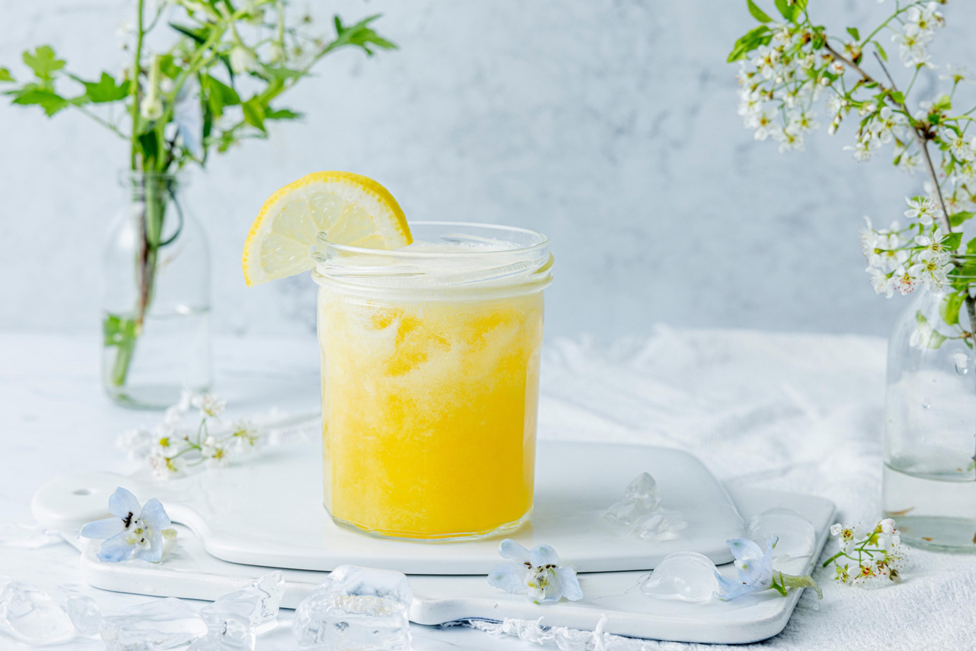ropisk sparkling limonade servert i et pent glass med sitronskive på kanten.
